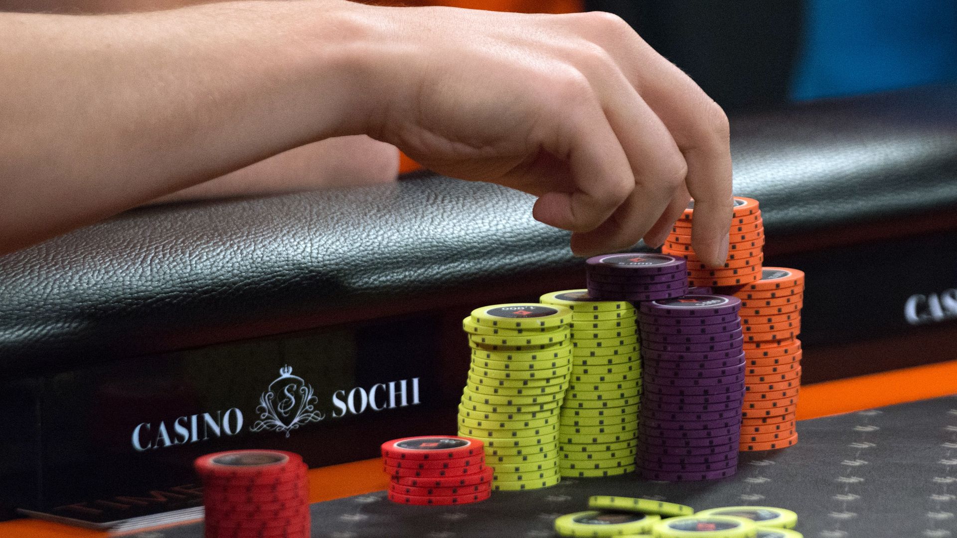 A gambler's hand reaching for poker chips