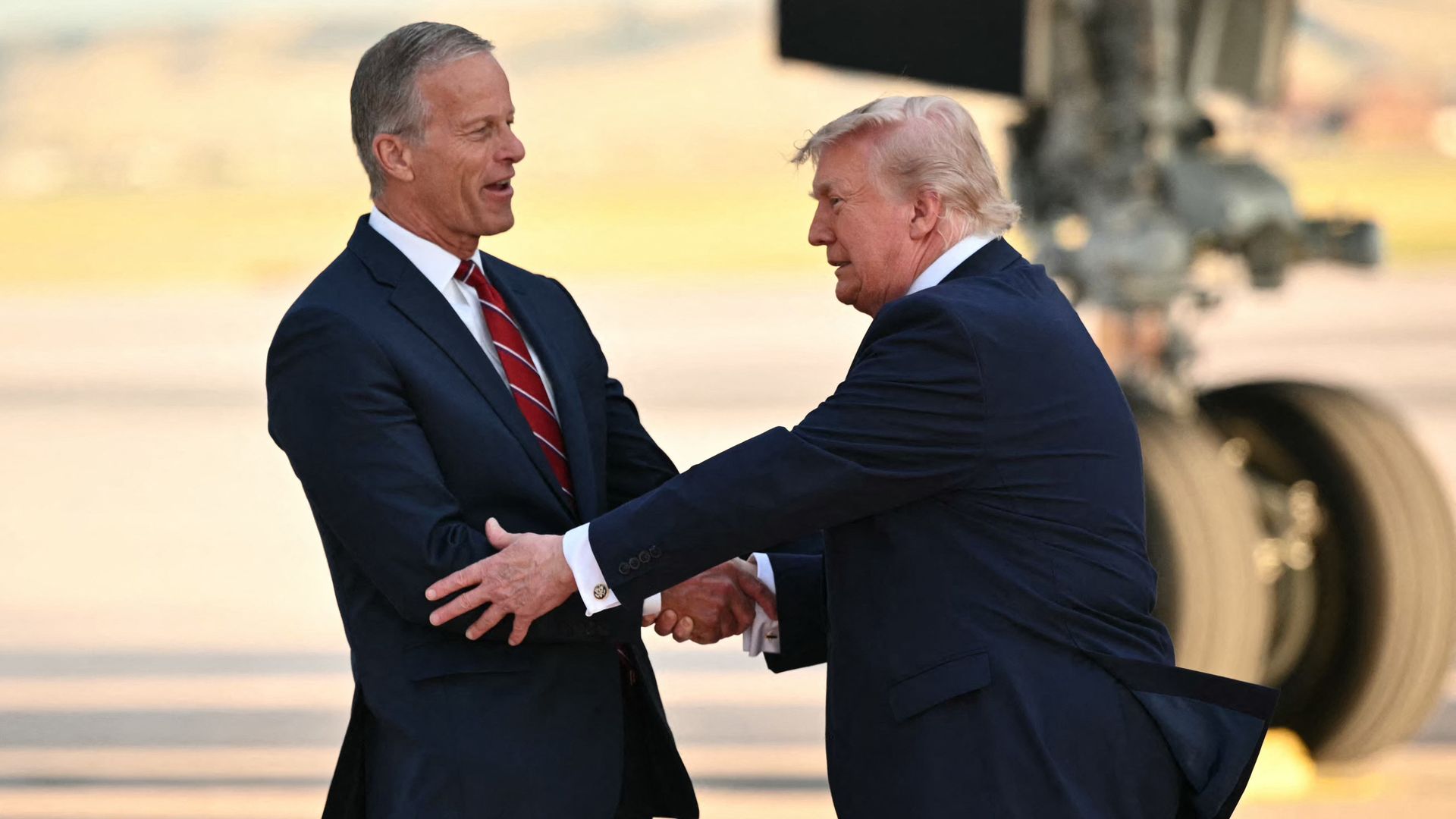 Majority Leader John Thune, Republican from South Dakota, greets US President Donald Trump as he steps off Air Force One upon arriving at Ellsworth Air Force Base, South Dakota 