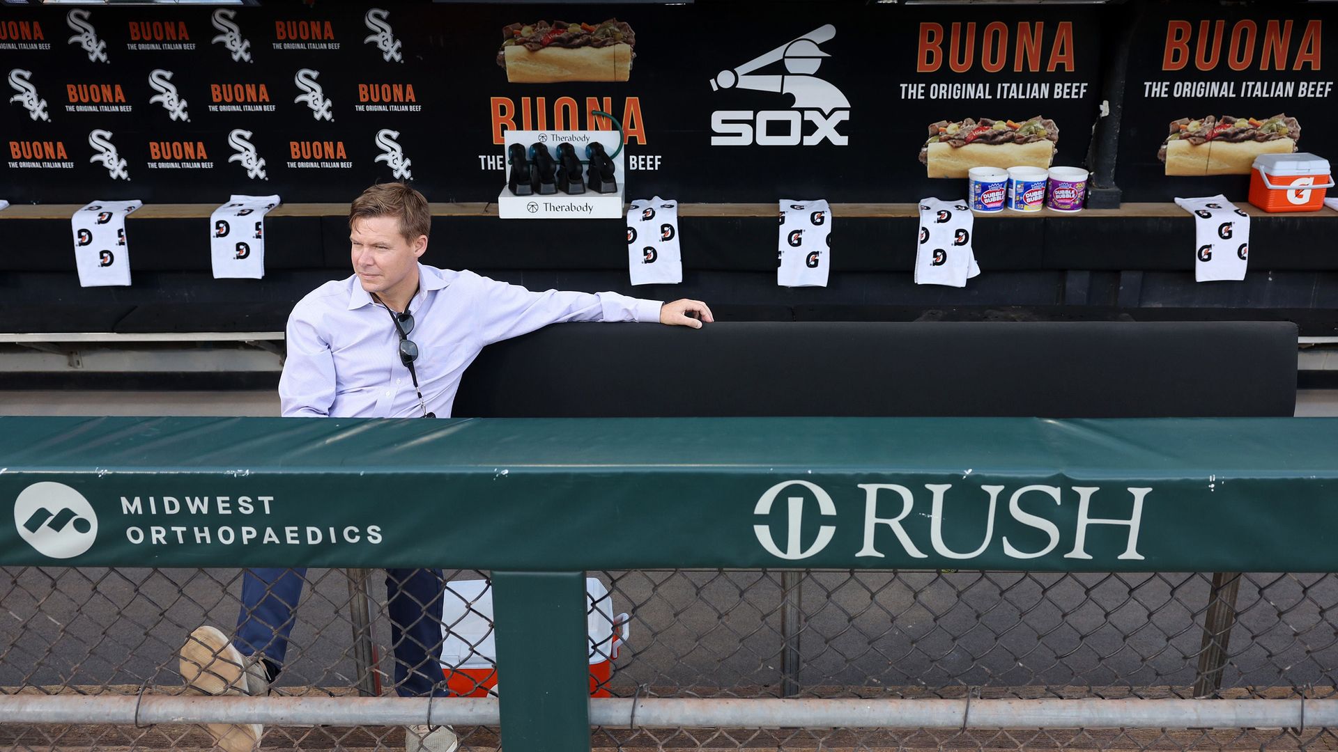 Photo of a man sitting in a baseball dugout 