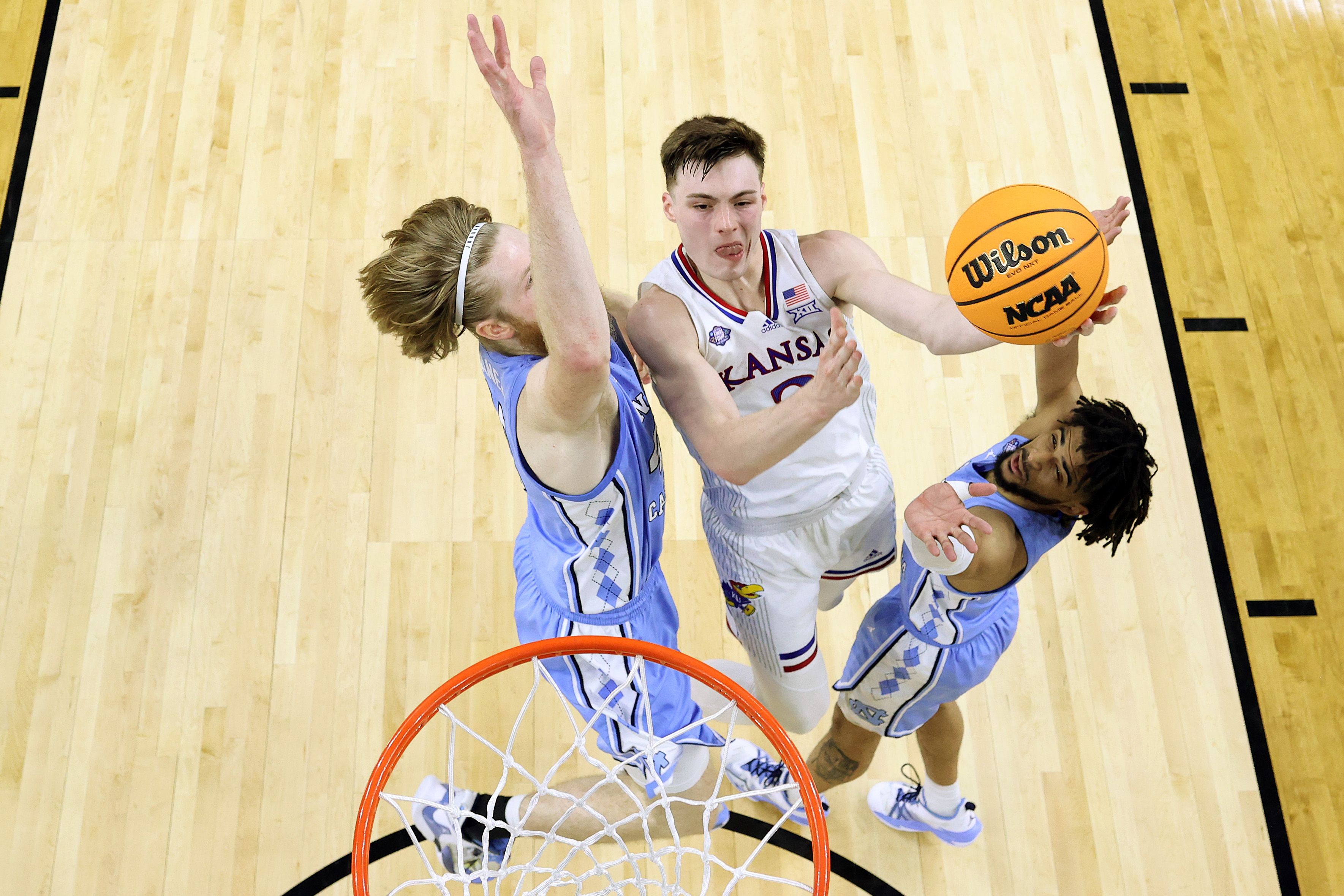 A man drives up to the basket with a basketball.