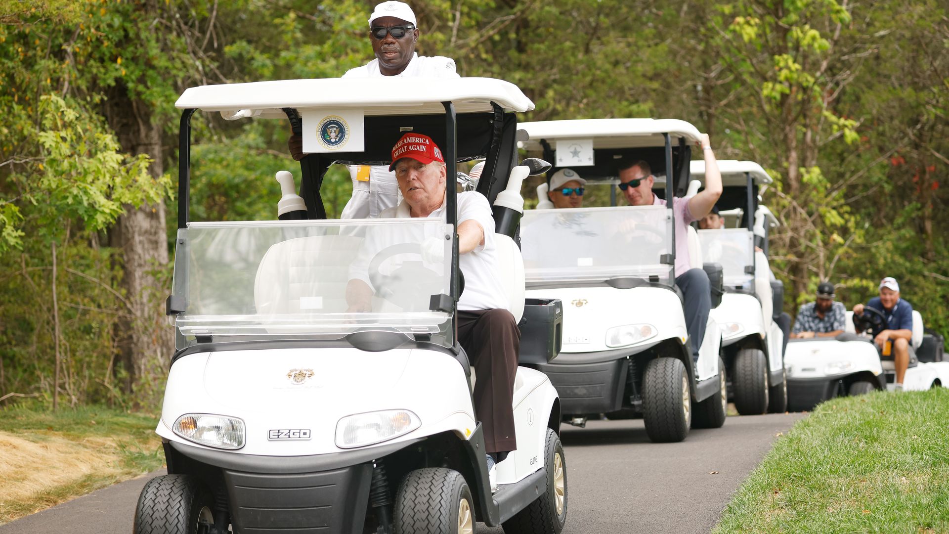 Former U.S. President Donald Trump drives his cart during the pro-am prior to the LIV Golf Invitational.