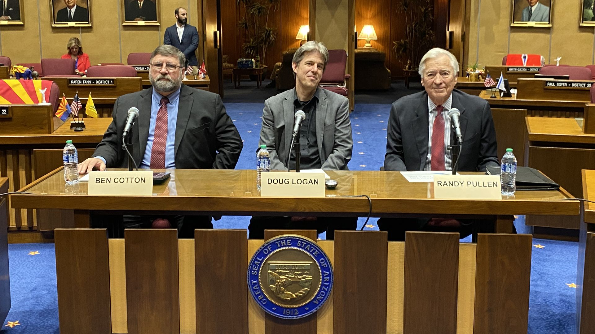 Three men sitting at a table. 