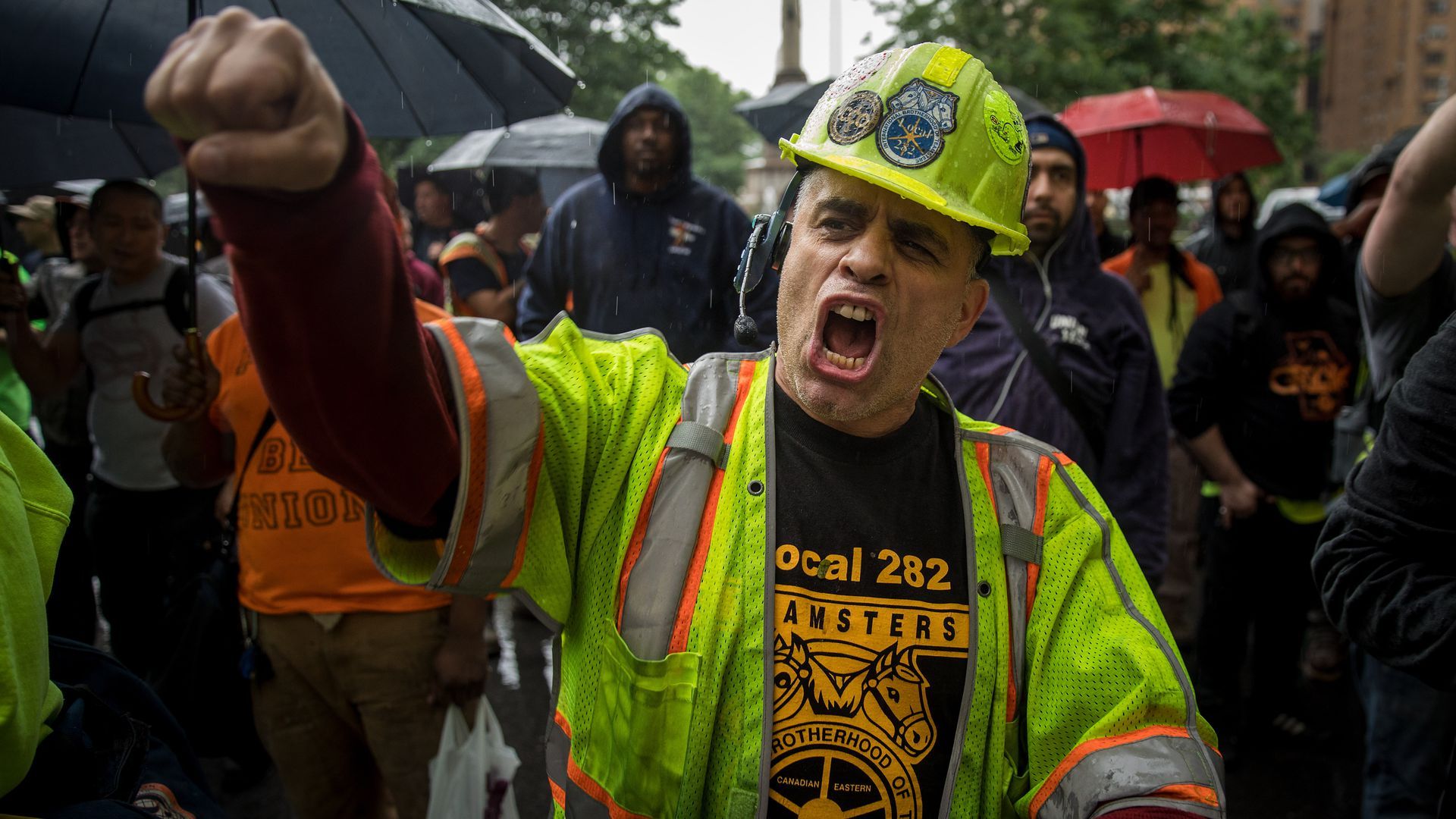 A construction worker protests with his fist in the air
