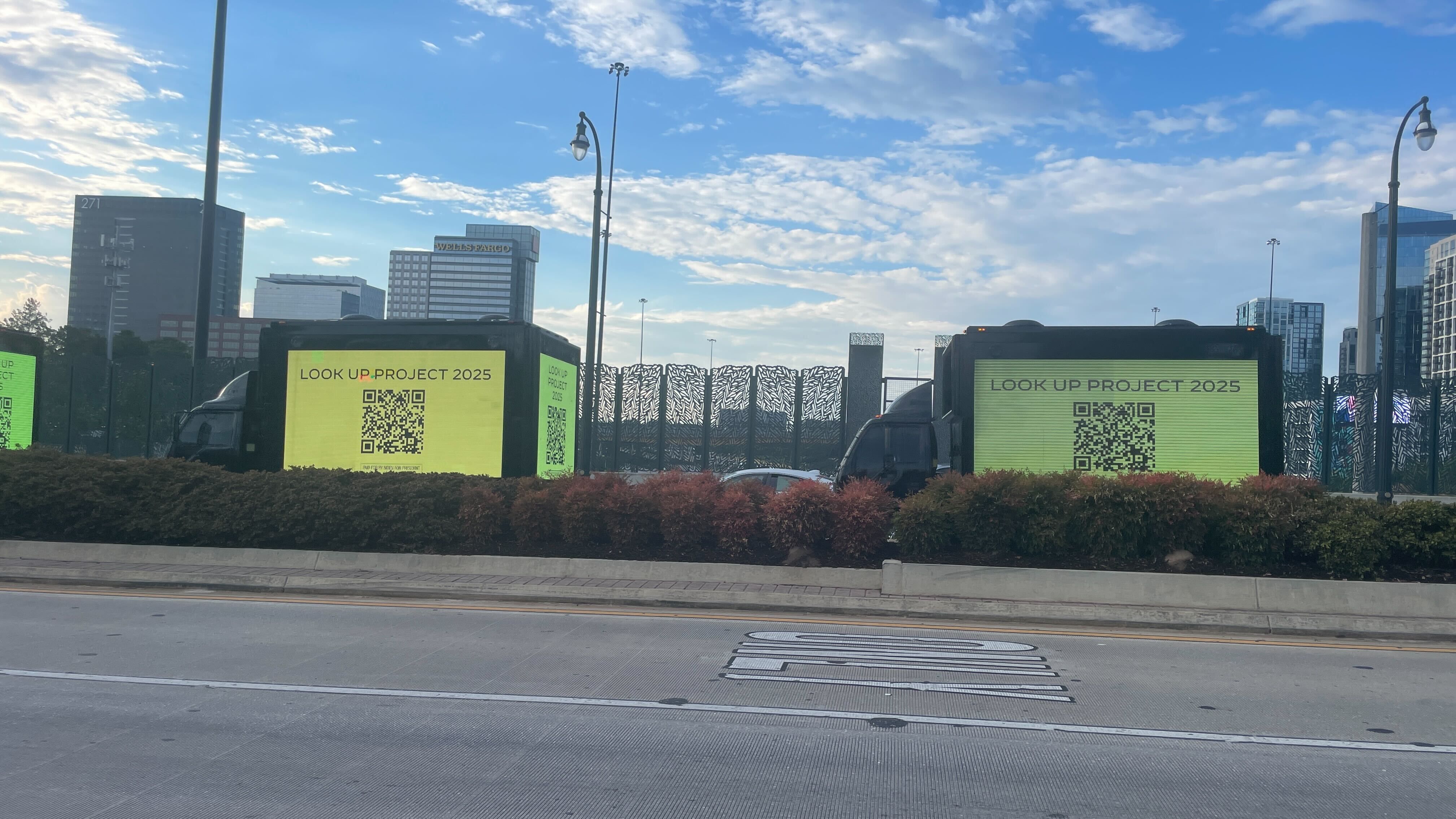 LED ad trucks displaying the message “look up Project 2025" alongside QR codes.