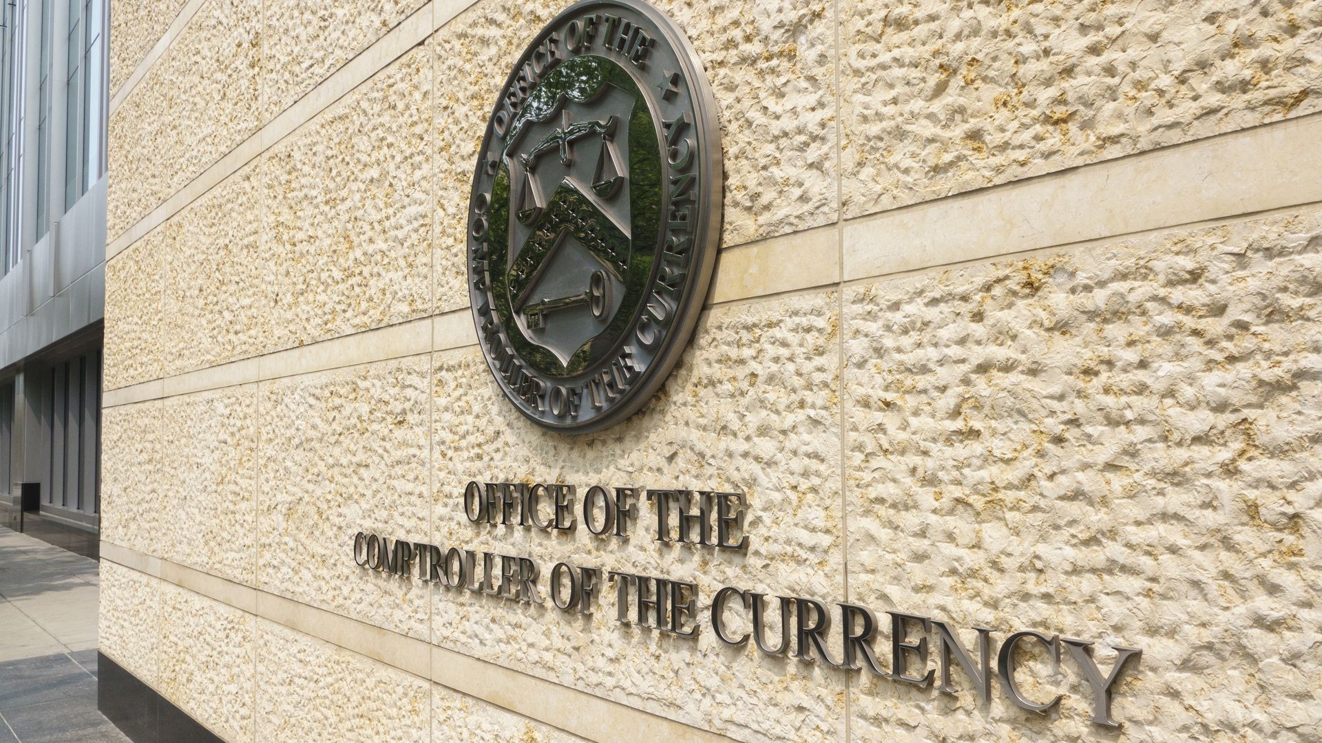 A sign is displayed at the Office of the Comptroller of the Currency (OCC) headquarters at Constitution Center on June 1, 2025 in Washington, DC.
