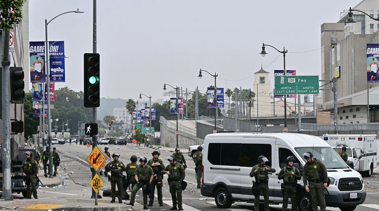 Law enforcement officers stand near a Los Angeles roadblock on June 9 following a night of protests in response to federal immigration raids.