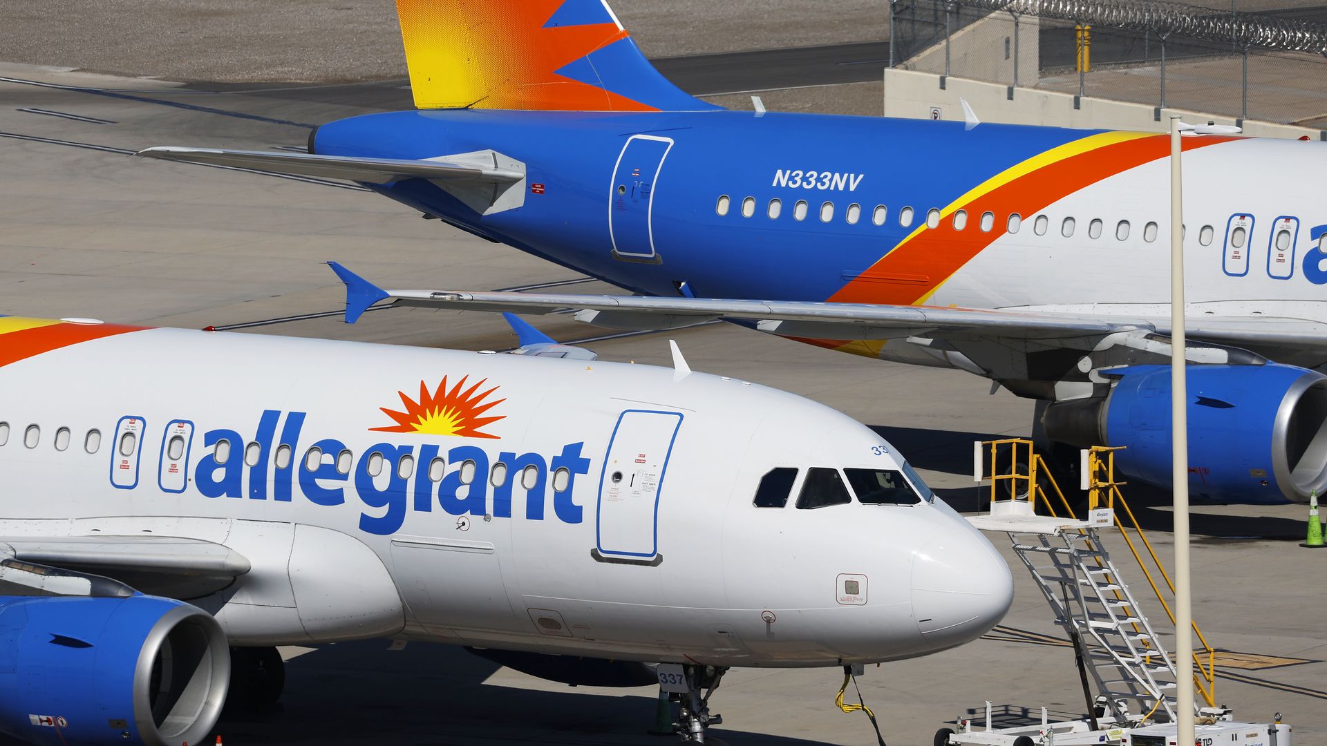 Two Allegiant Airlines planes are shown parked on a runway.