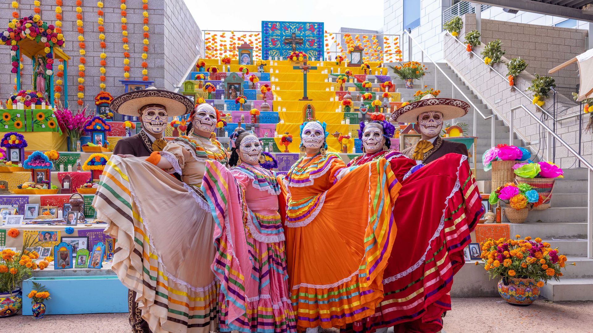 People in front of a Dia de los Muertos ofrenda. 