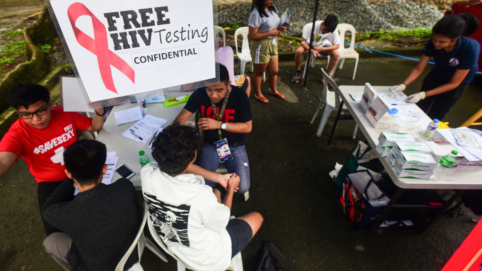 Medical technologists speak to people about free HIV testing in Manila.