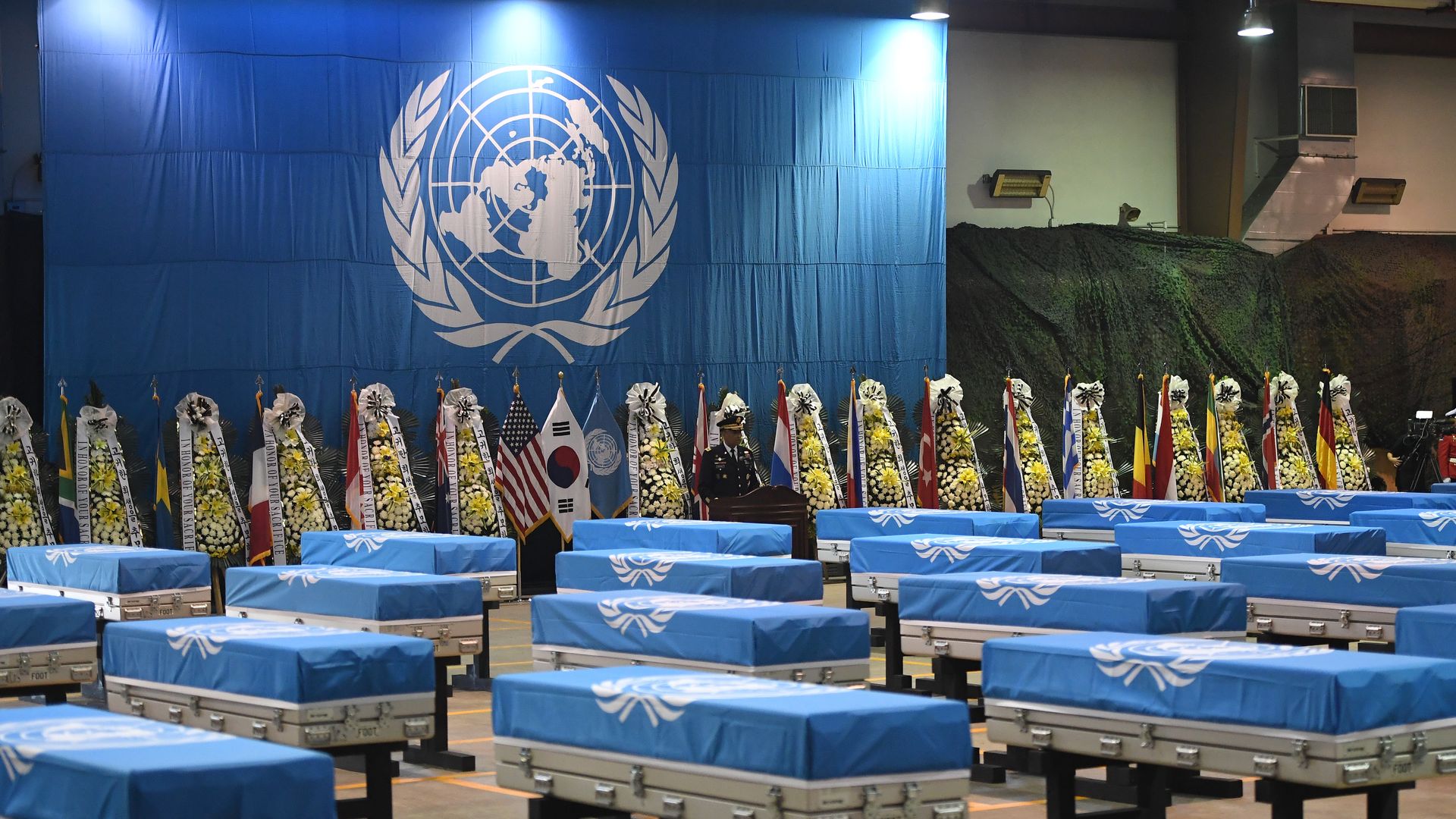 Caskets covered in blue sheets at a UN repatriation ceremony