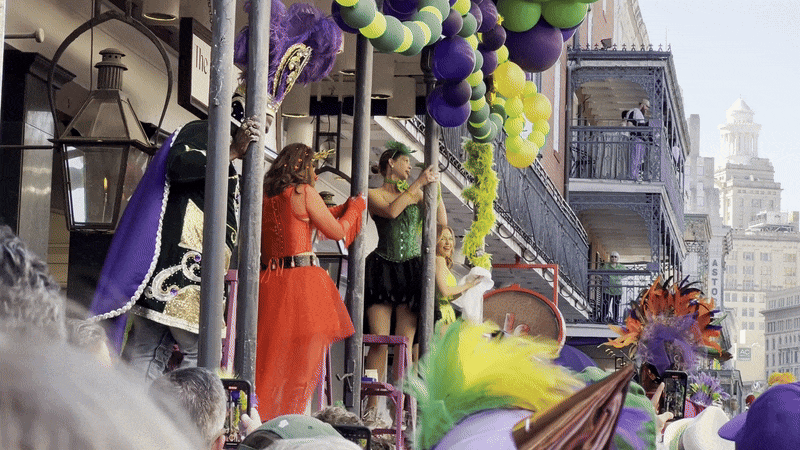 A woman rubs her hand down the column outside of a hotel while standing on a ladder.