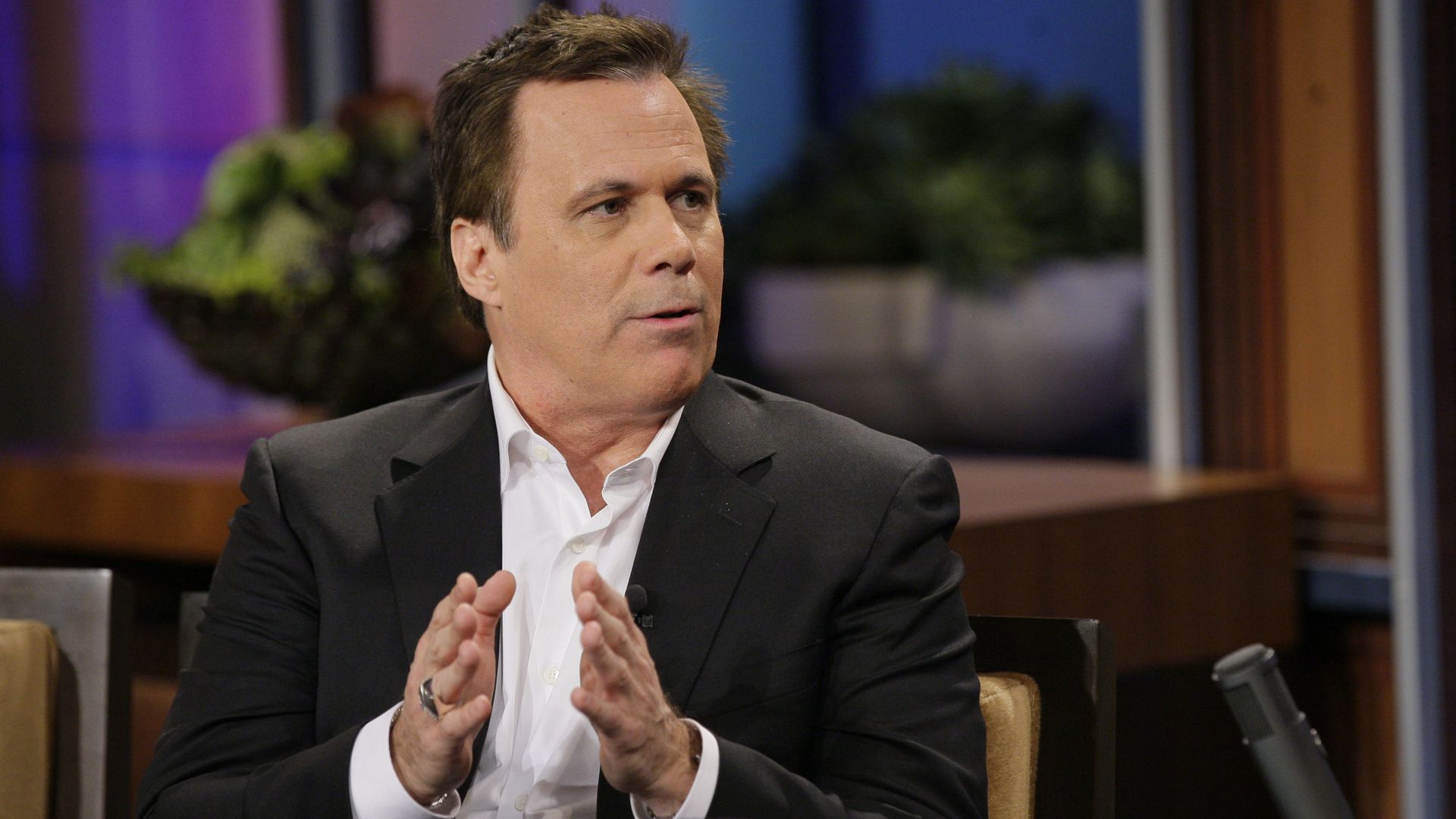 Photo of a man in a chair talking during an interview. 