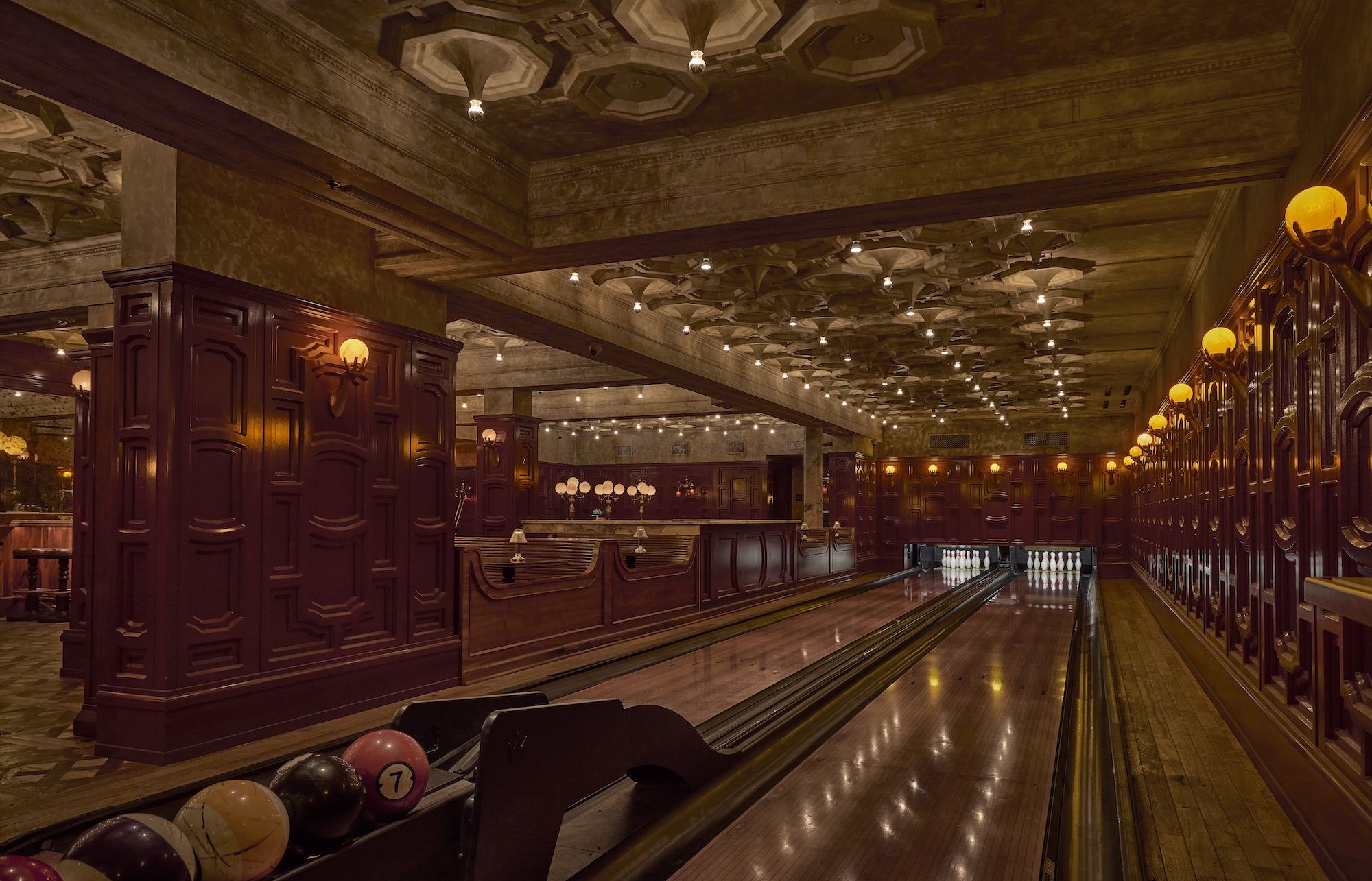 A renovated, historic bowling alley with ornate ceilings, walls and lighting.