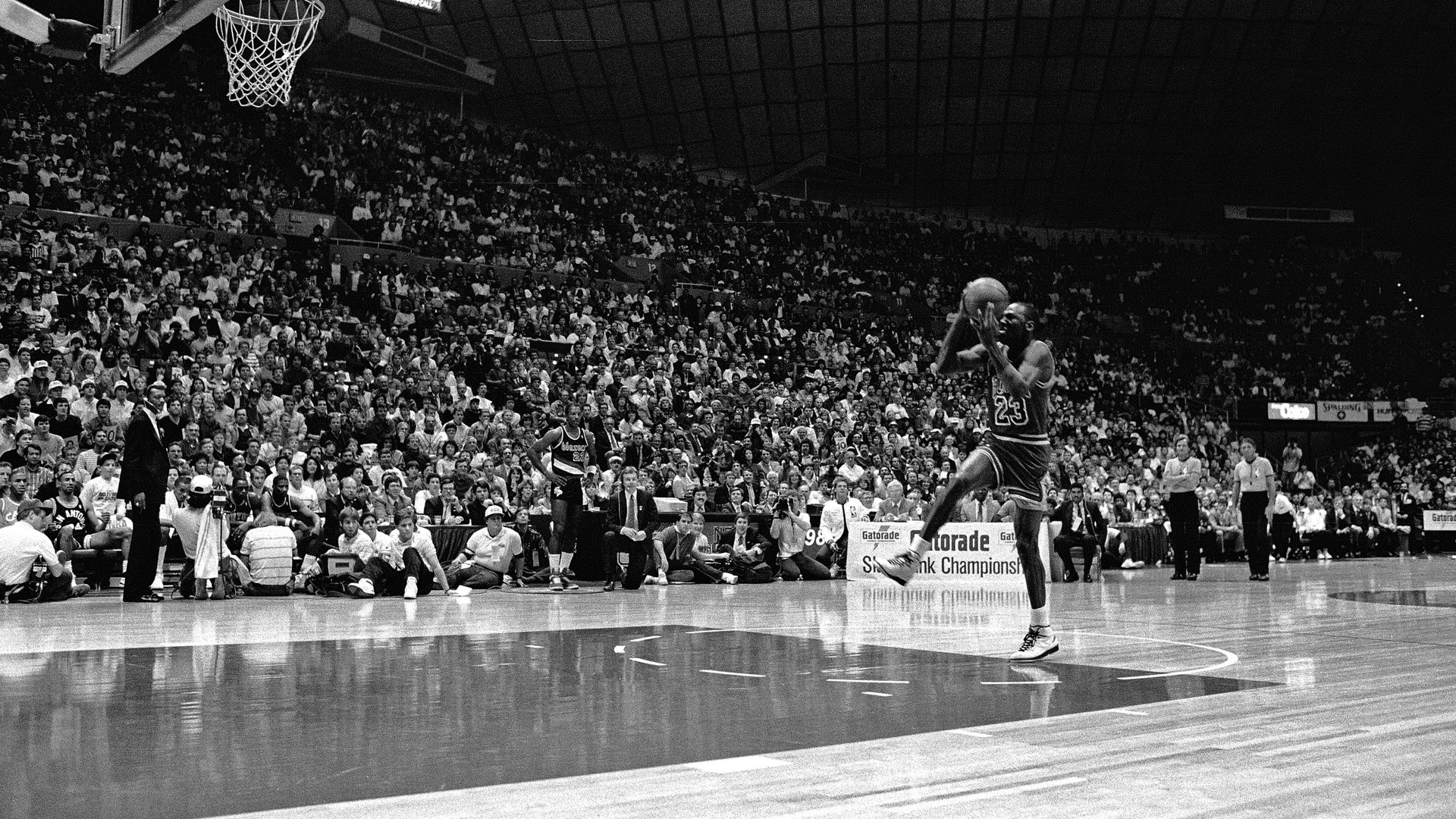 Photo of a basketball player jumping towards the hoop