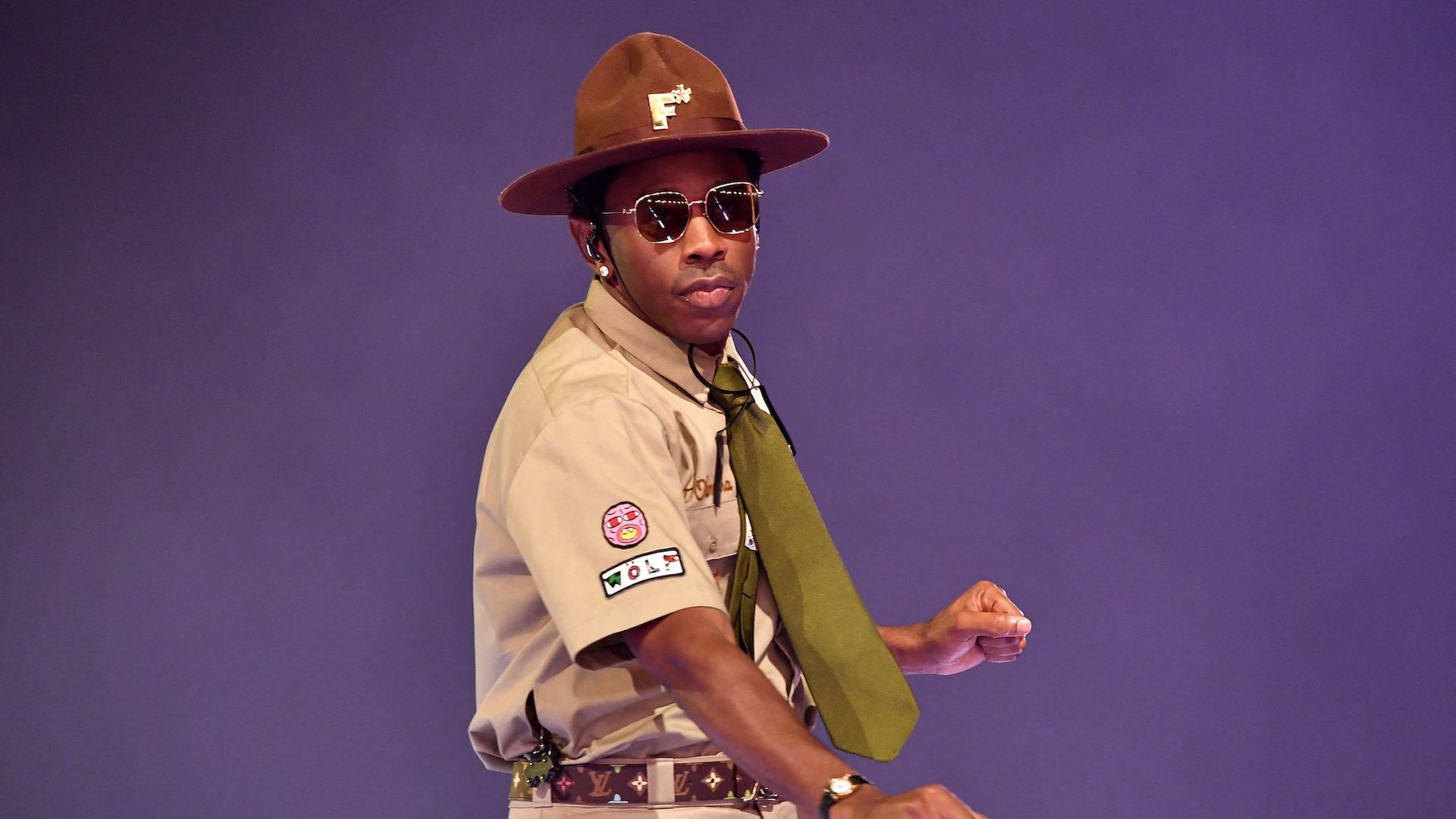 Tyler, the Creator in a boy scout uniform performing on stage.