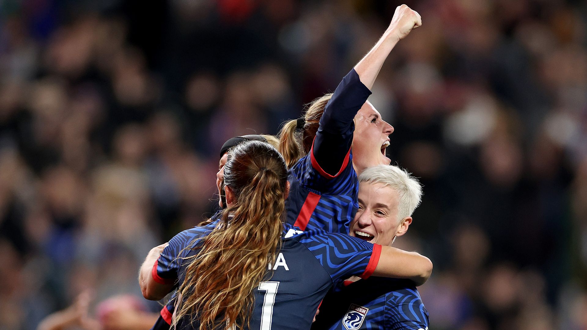 OL Reign team members celebrate after a win on the soccer field.