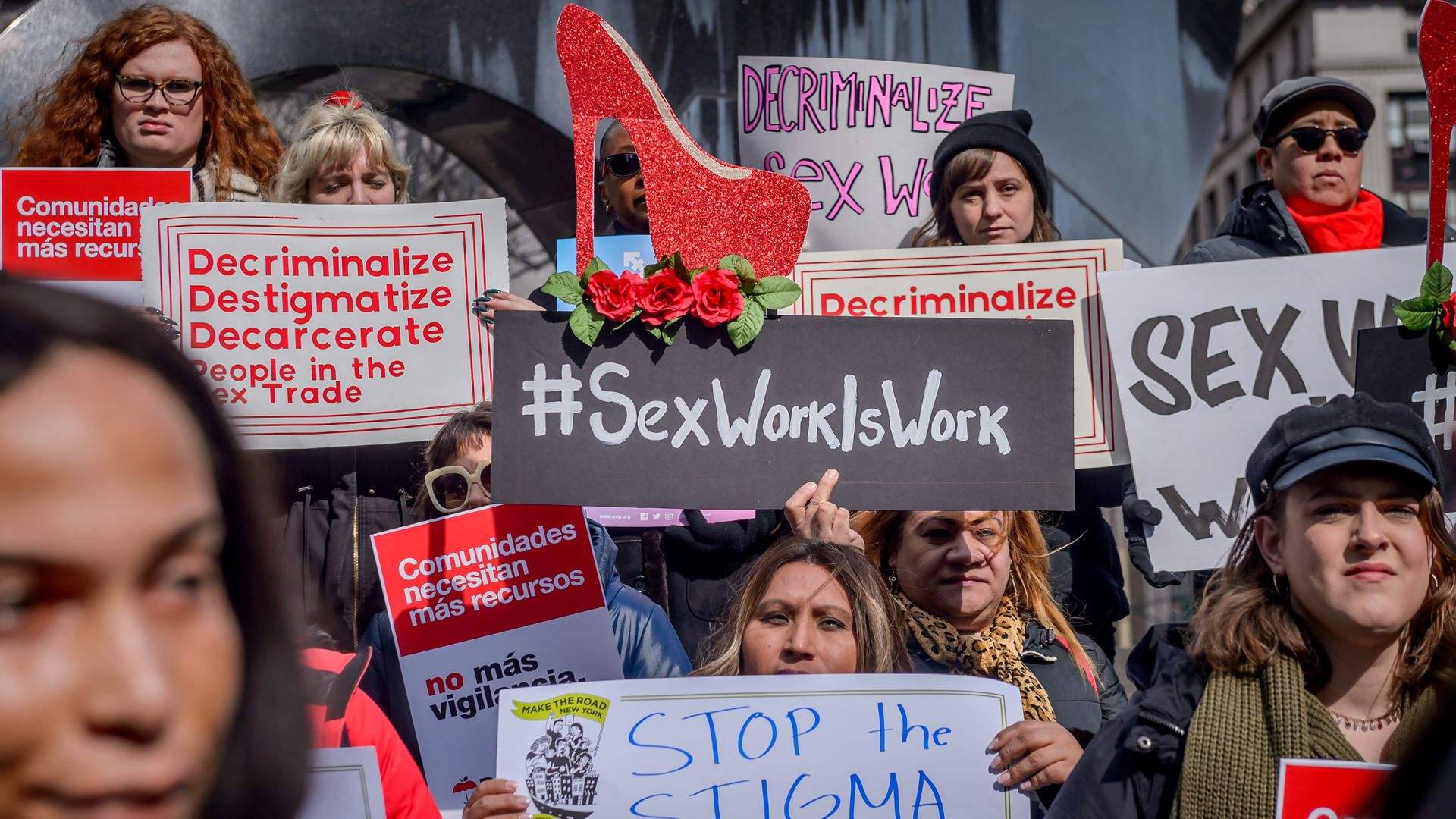 Picture of people carrying signs in support of decriminalizing sex work