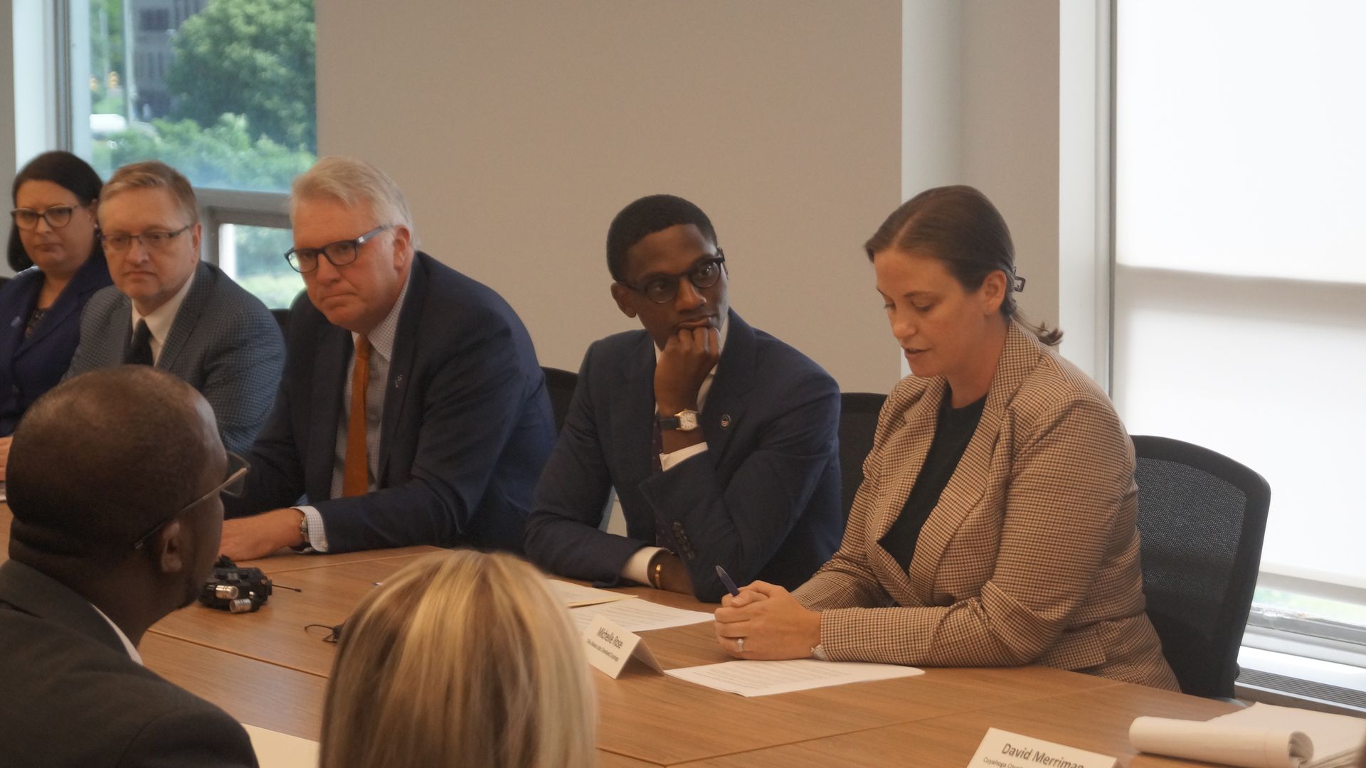 Suited leaders in Cleveland sit around a conference table.