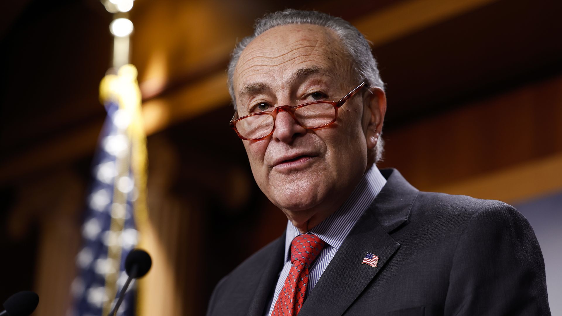 Chuck Schumer looks over his lowered glasses at a Capitol press conference