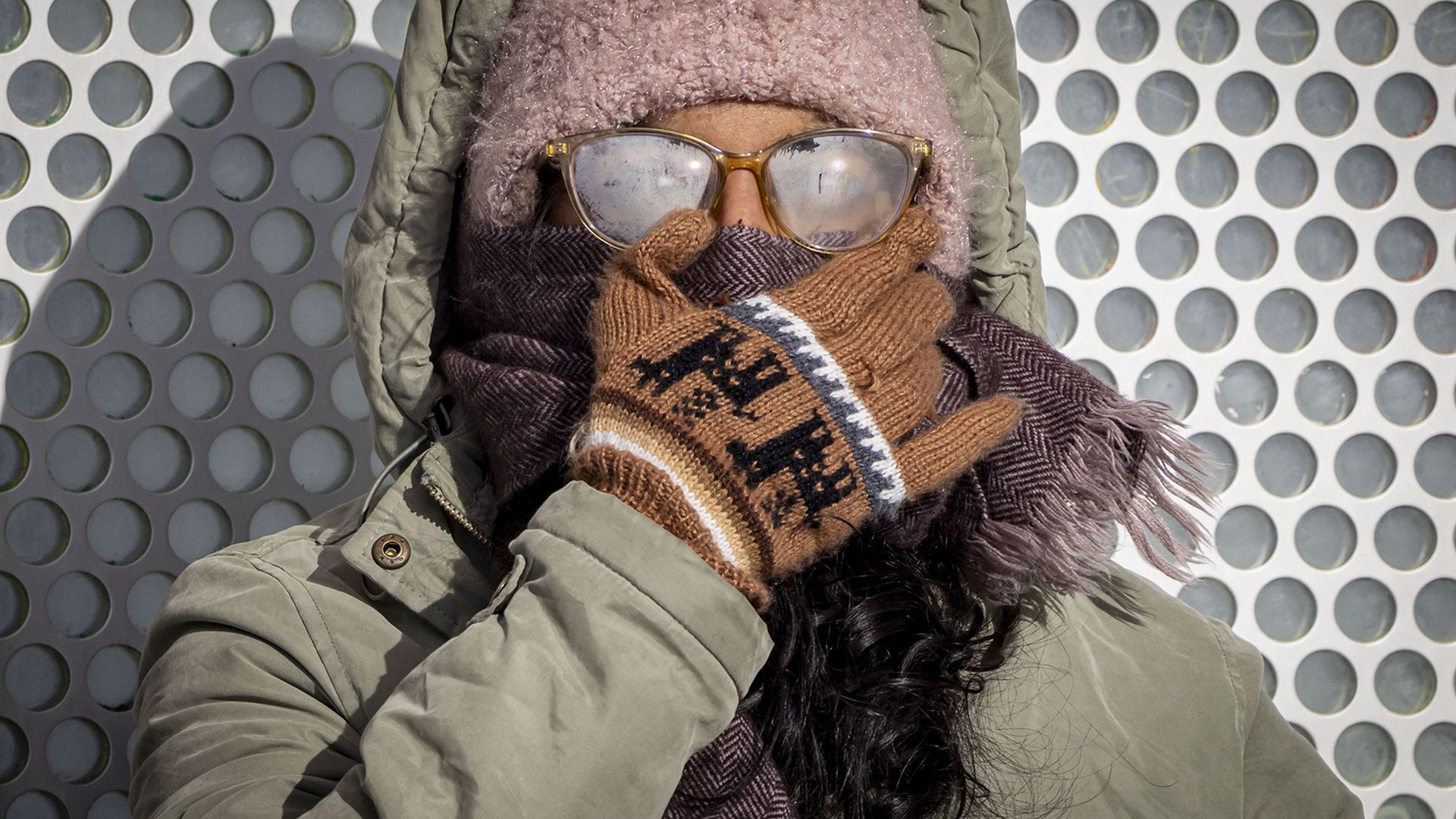 Photo of a woman dressed up in outdoor wear standing in the cold
