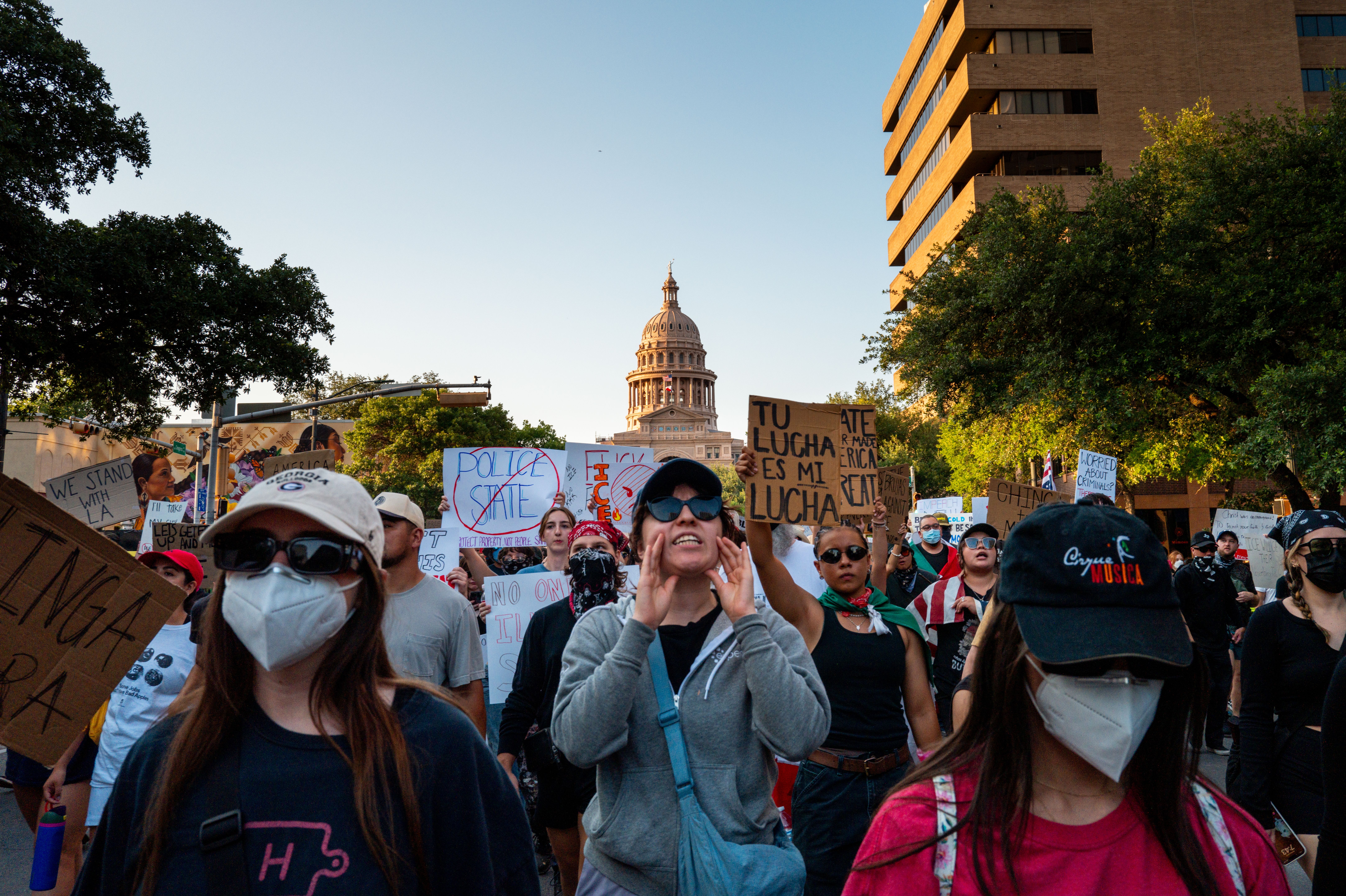 Protesters hold signs in the street at a downtown Austin march against the Trump administration's immigration enforcement.