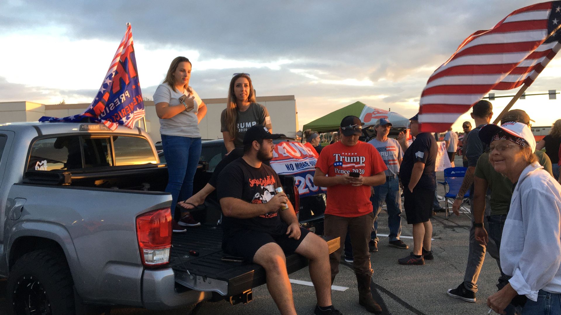 Supporters of the US president who were unable to enter the campaign venue because it was full, listen to his speech sitting in their pickup truck