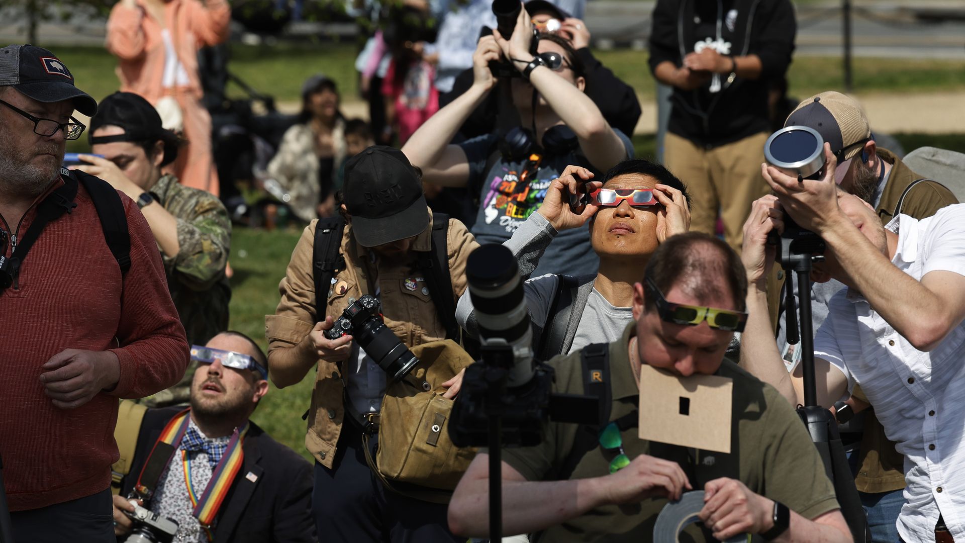 Photographers and viewers crowd for a glimpse of the eclipse on the National Mall.