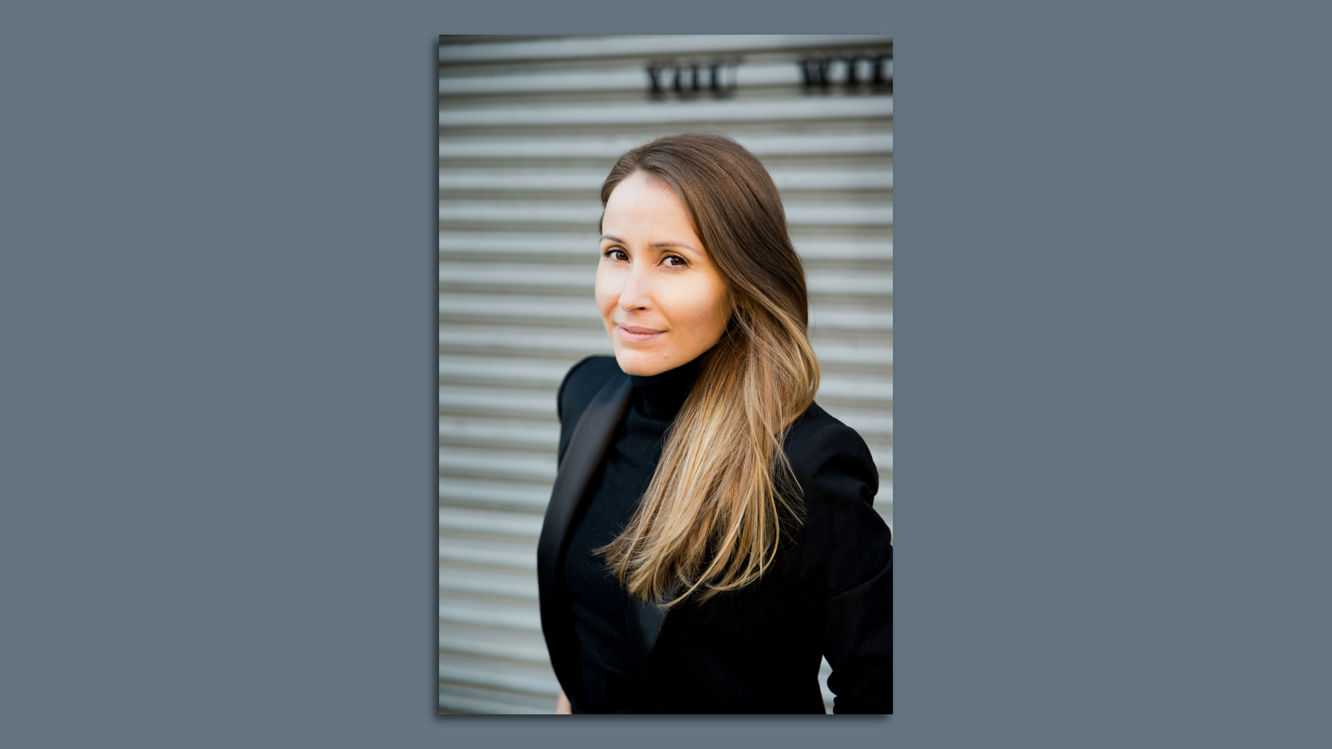 A portrait of a woman in a black jacket and turtleneck with light brown hair. 