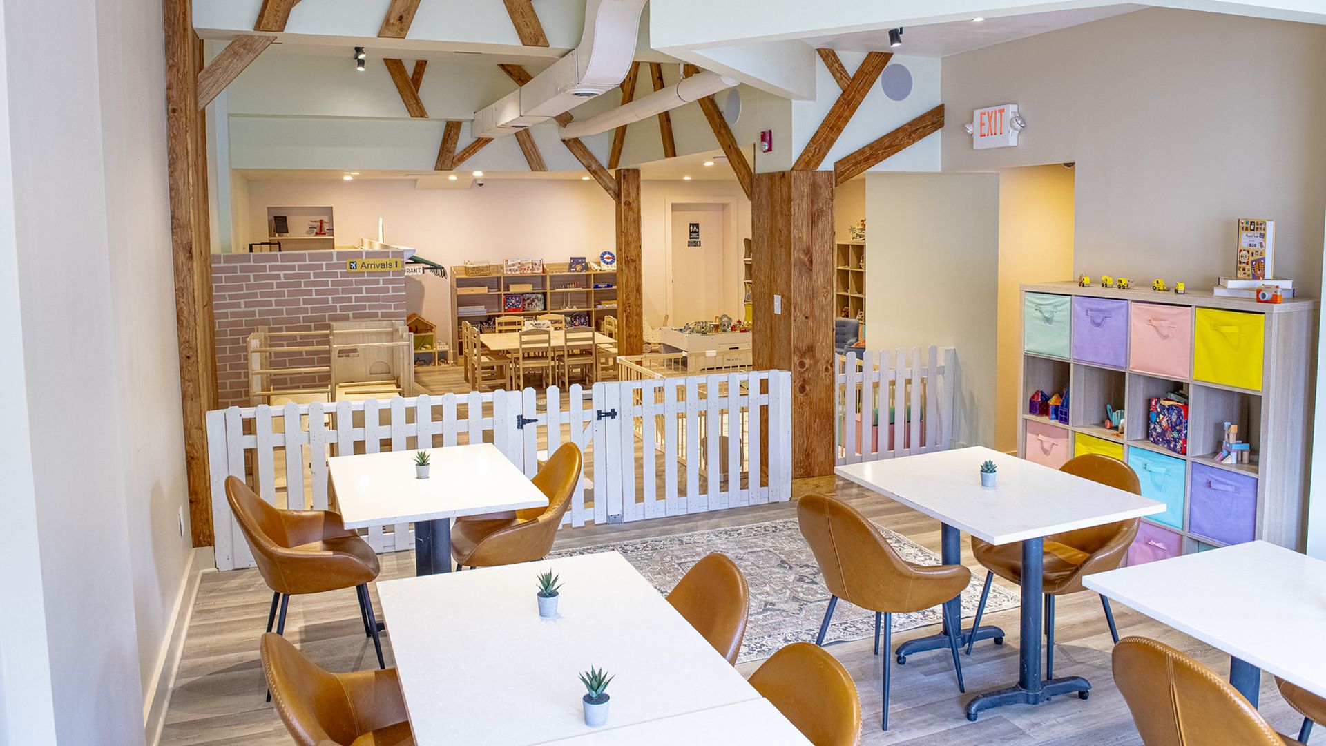 A photo showing a children's play space, with café seating outside of it.