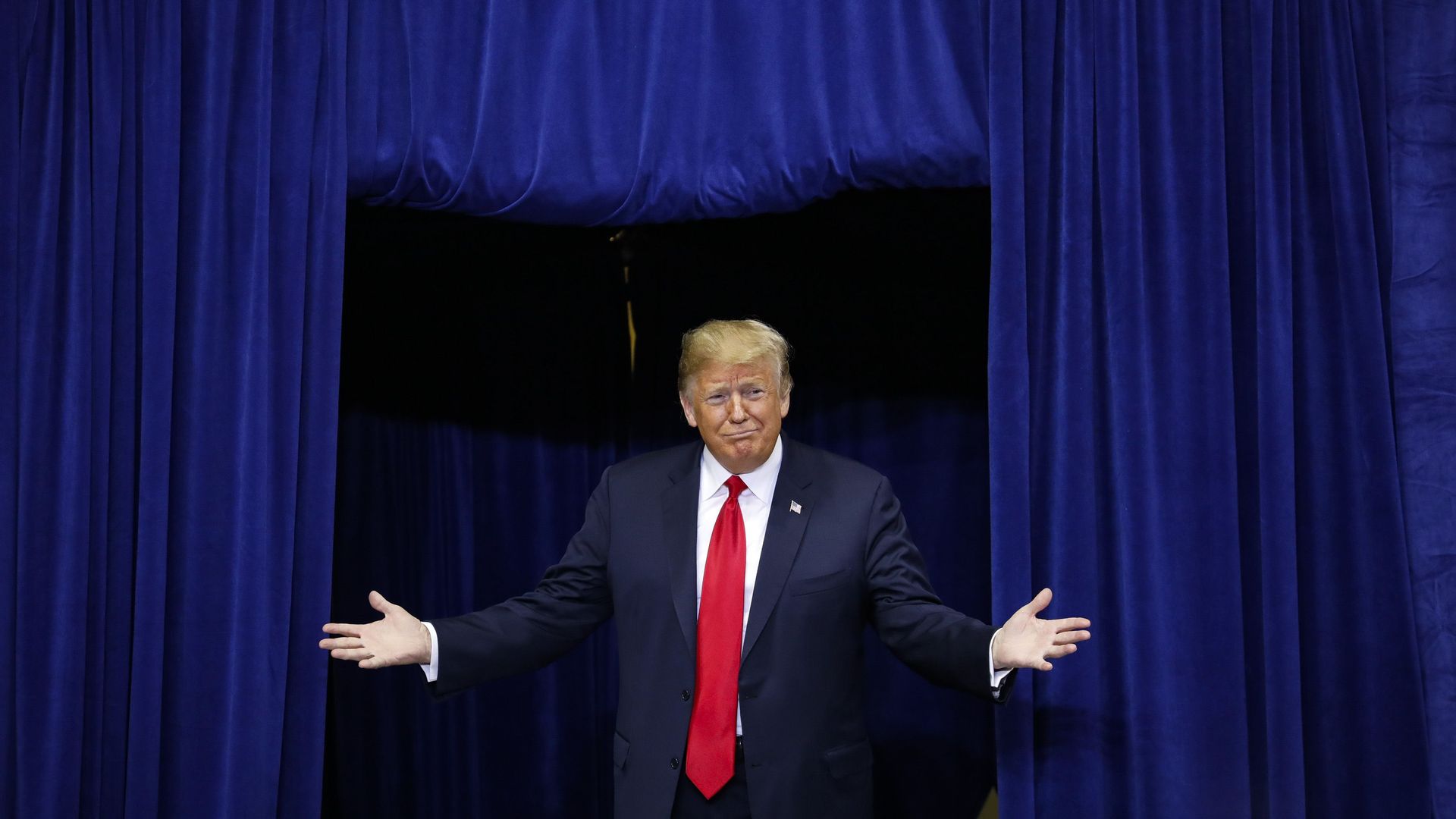 Donald Trump holding out his hands on stage