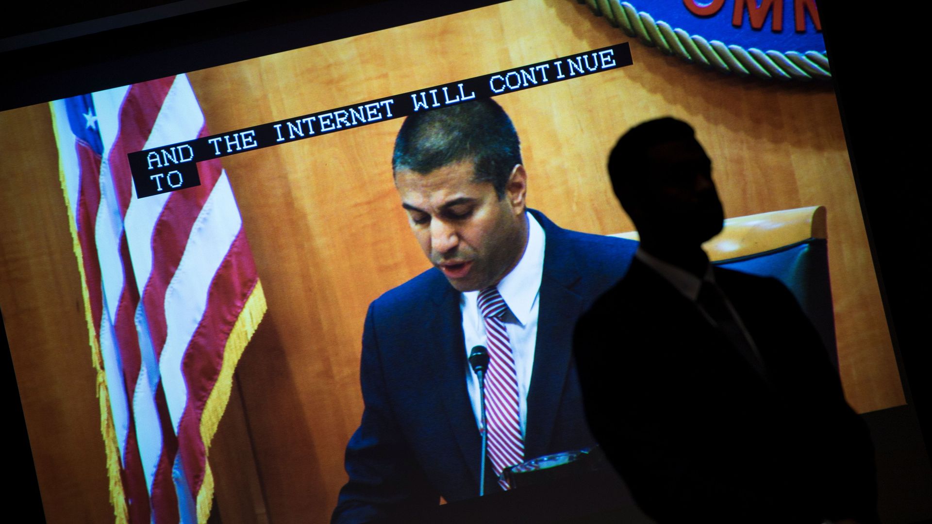 FCC Chairman Ajit Pai is shown on a screen at the agency