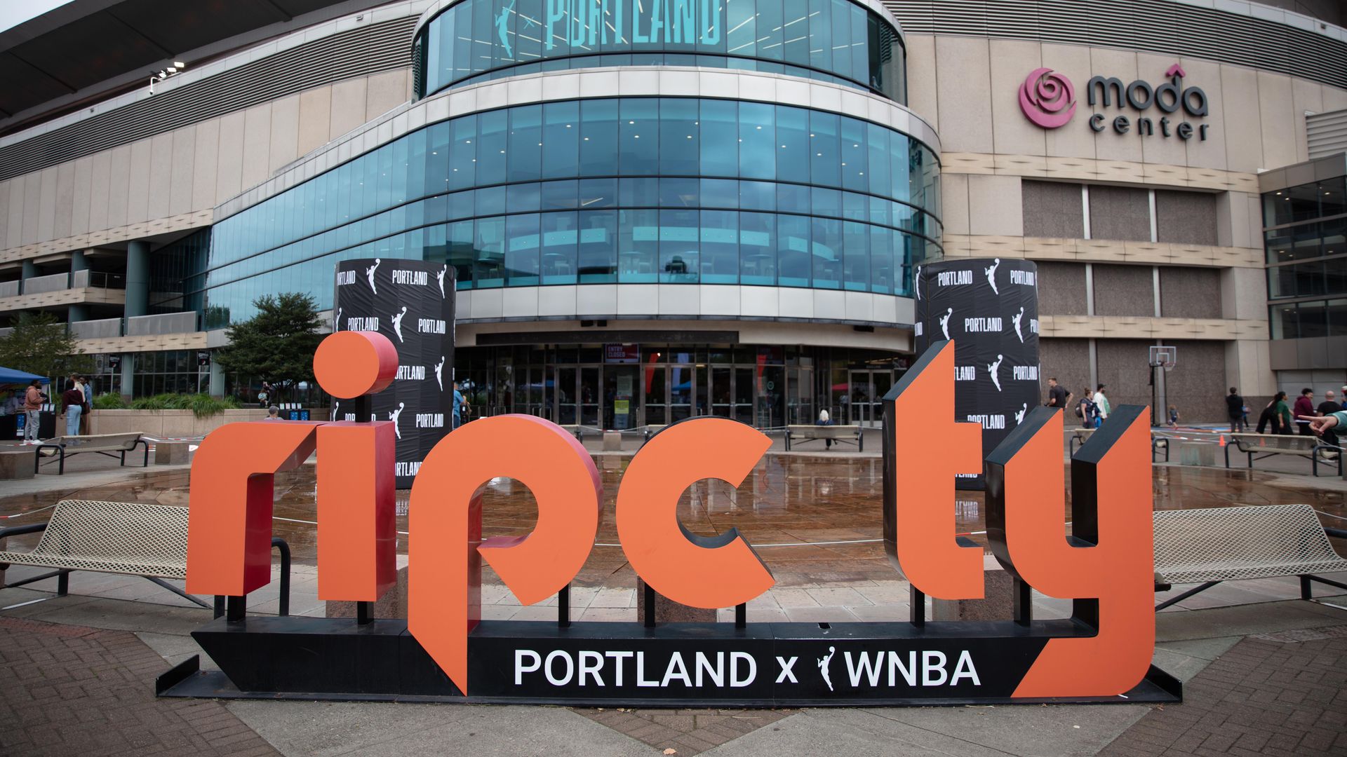 AN exterior shot of the Moda Center in Portland shows the Rip City logo with the words "Portland X WNBA" along the bottom.