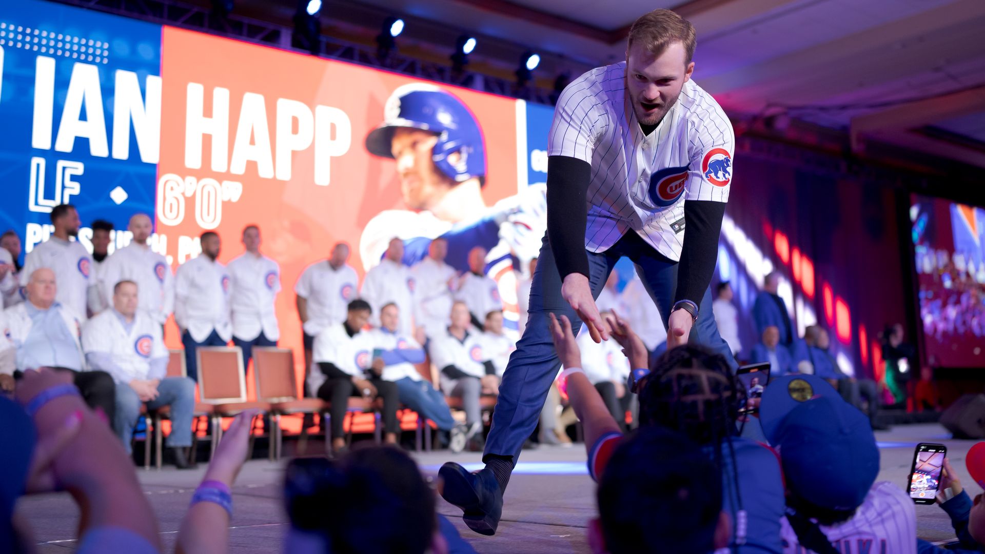 Chicago Cubs player shaking hands with a row of young fans at Cubs Convention in Chicago.