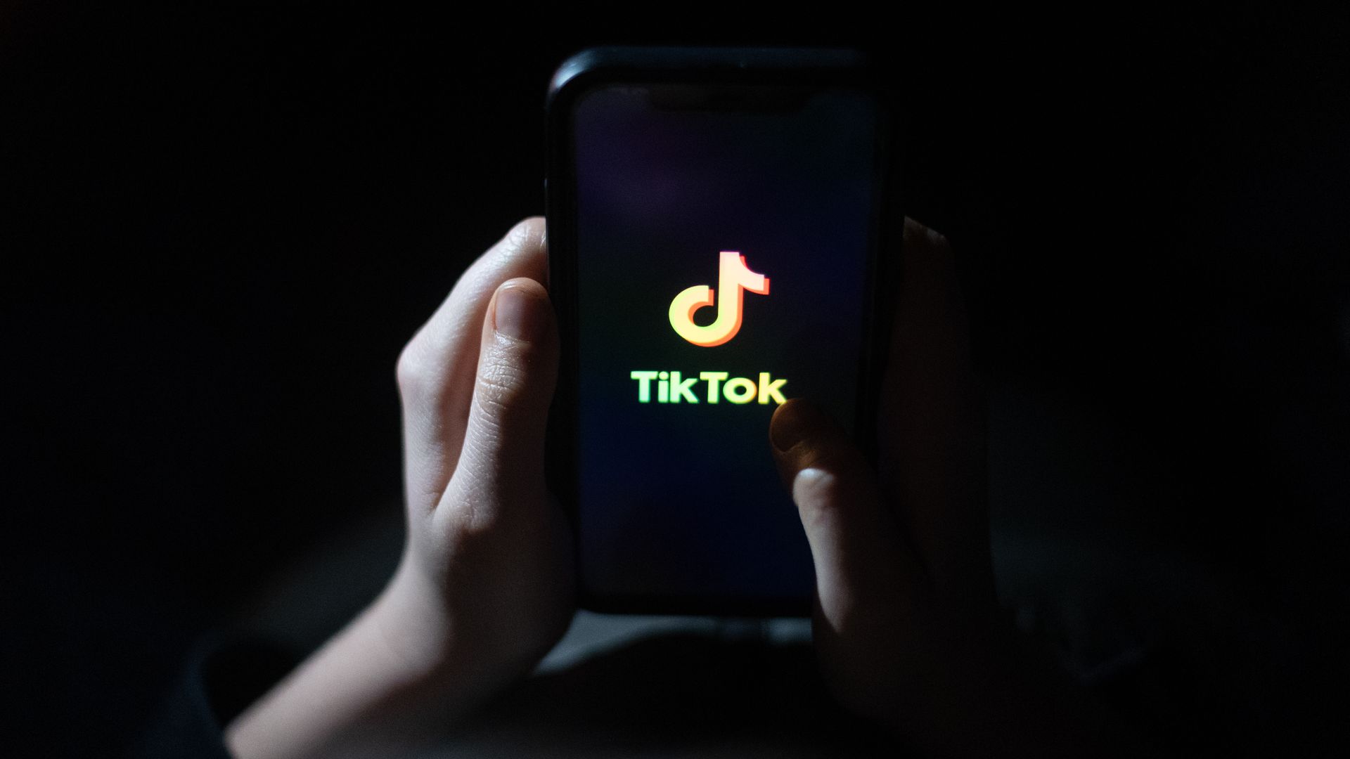 A person in Bath, England, holding a phone with TikTok's logo on March 10.