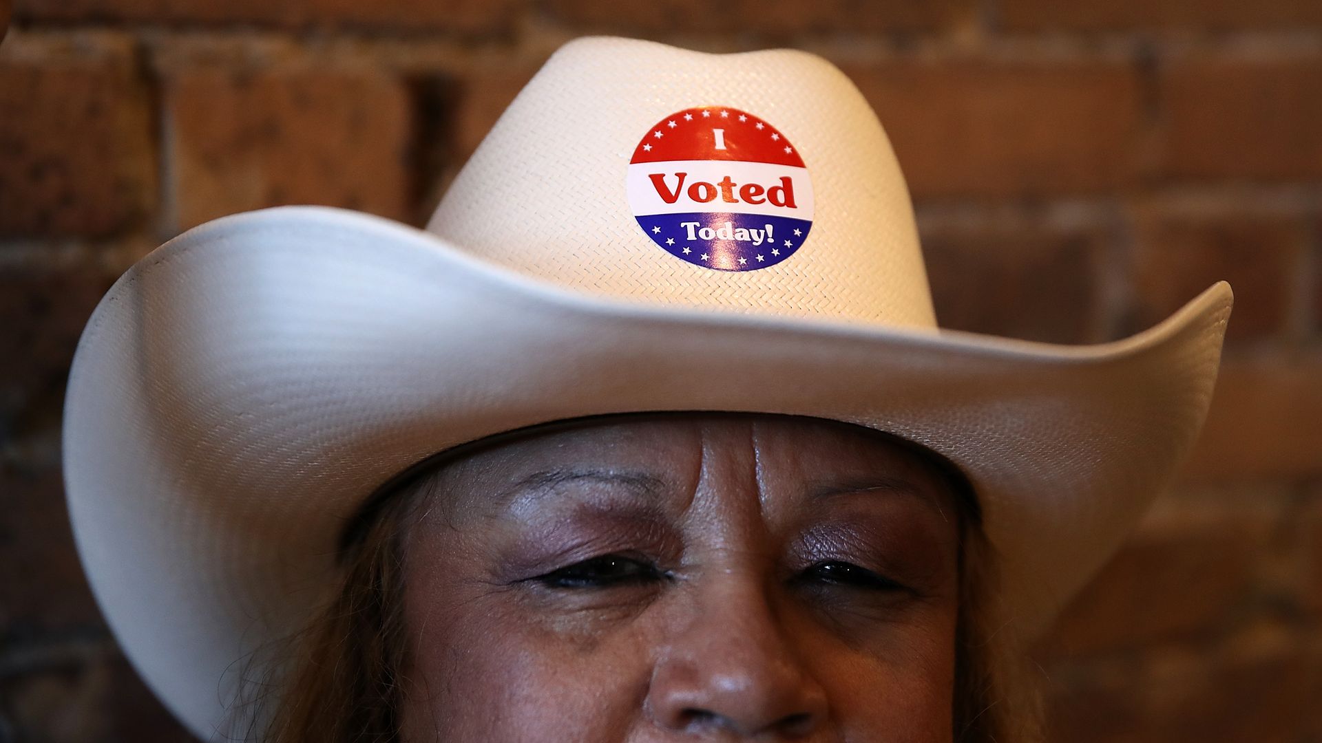 A photo of a woman wearing a cowboy hat with an I voted sticker