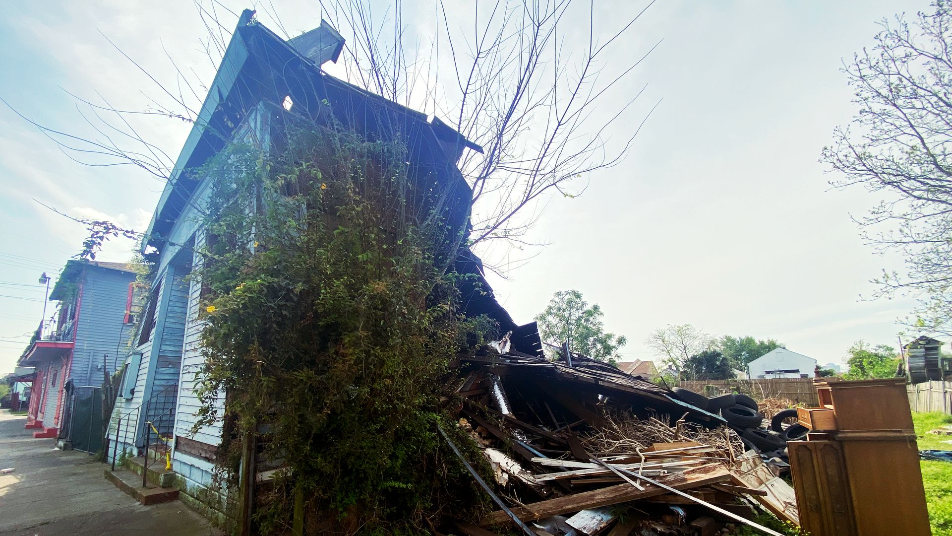 Photo shows the Holy Aid and Comfort Spiritual Church in disrepair. The blue facade facing the street is still upright, but the rest has collapsed.