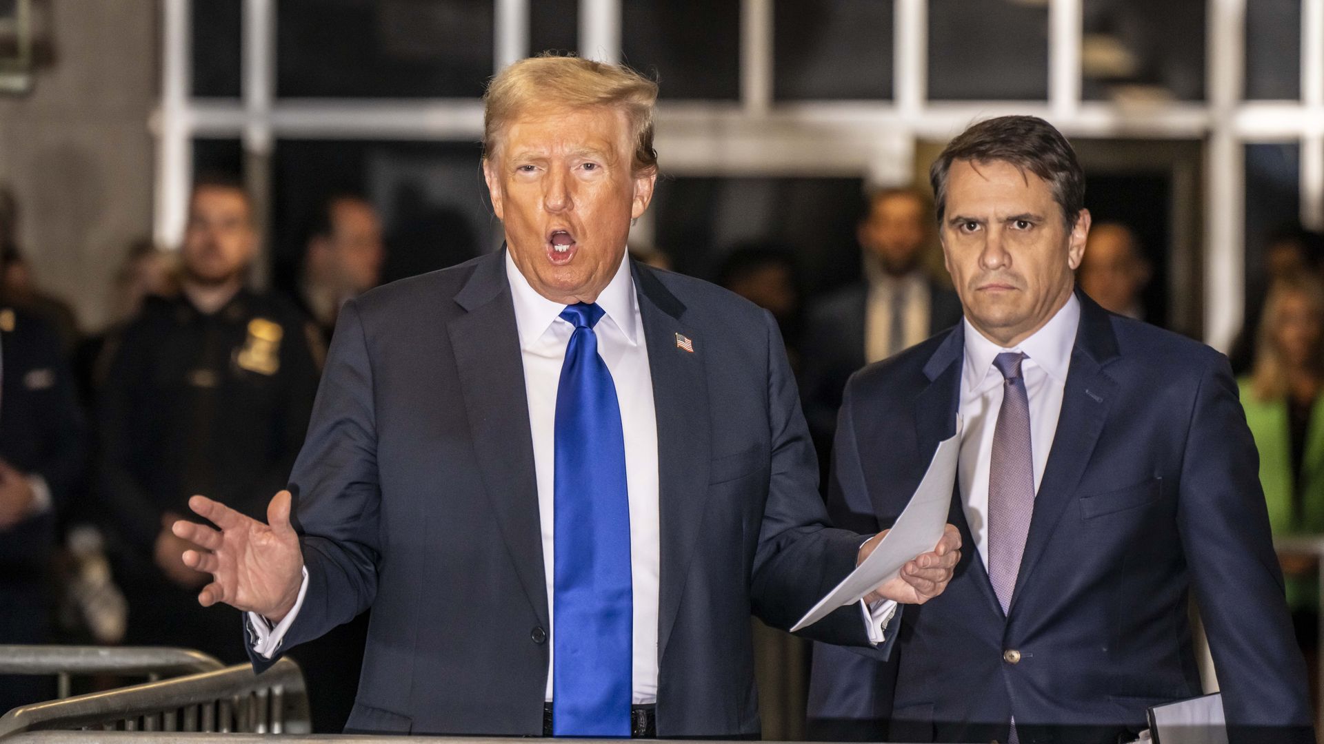 Trump speaks as attorney Todd Blanche stands beside him outside a New York courthouse.