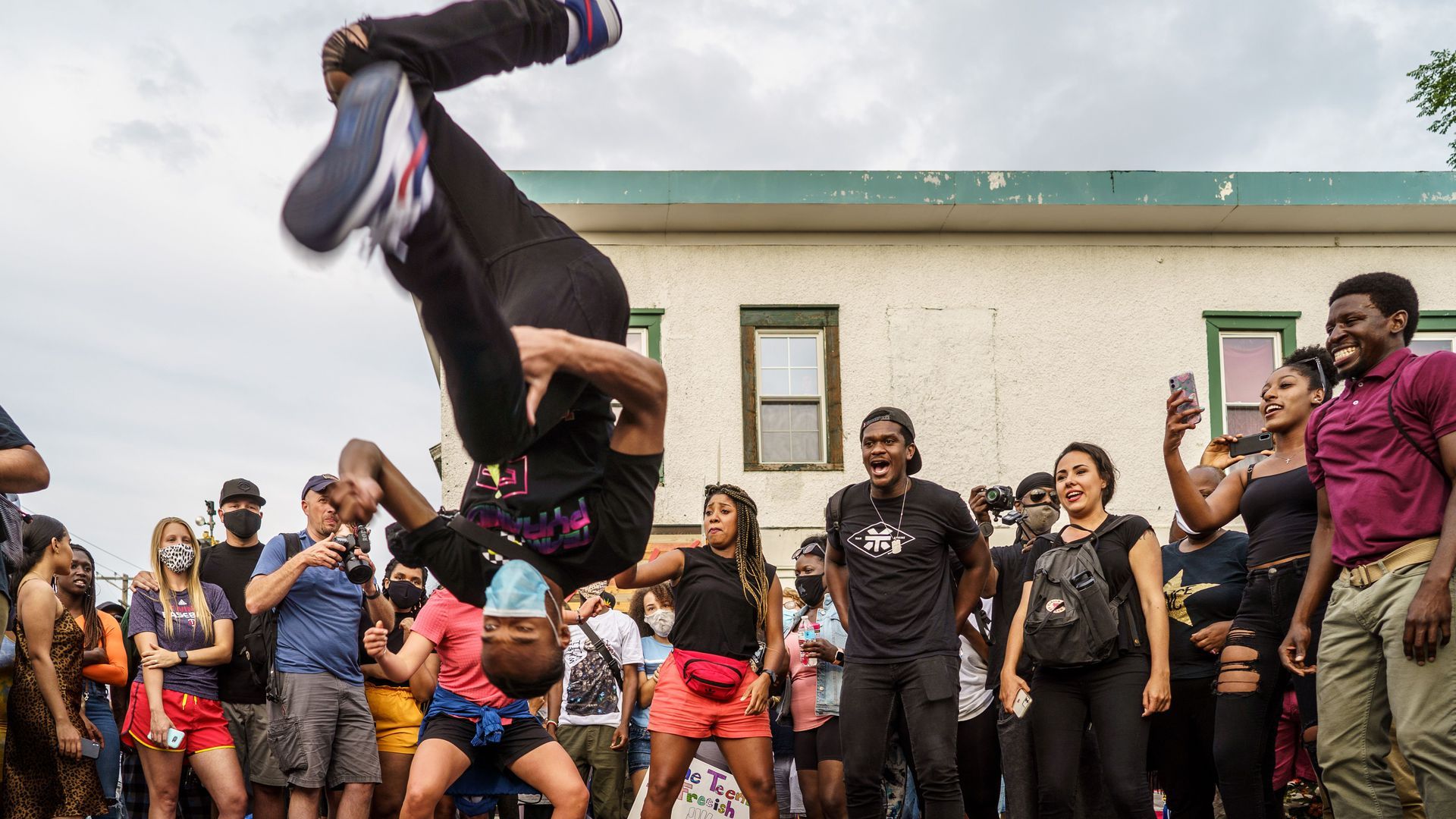 A man doing a backflip and people celebrating Juneteenth last year in George Floyd Square.