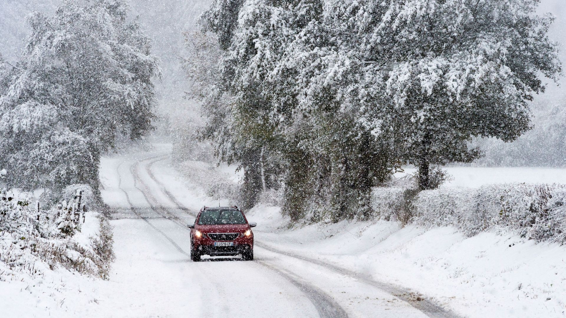 red car driving on a snowy road