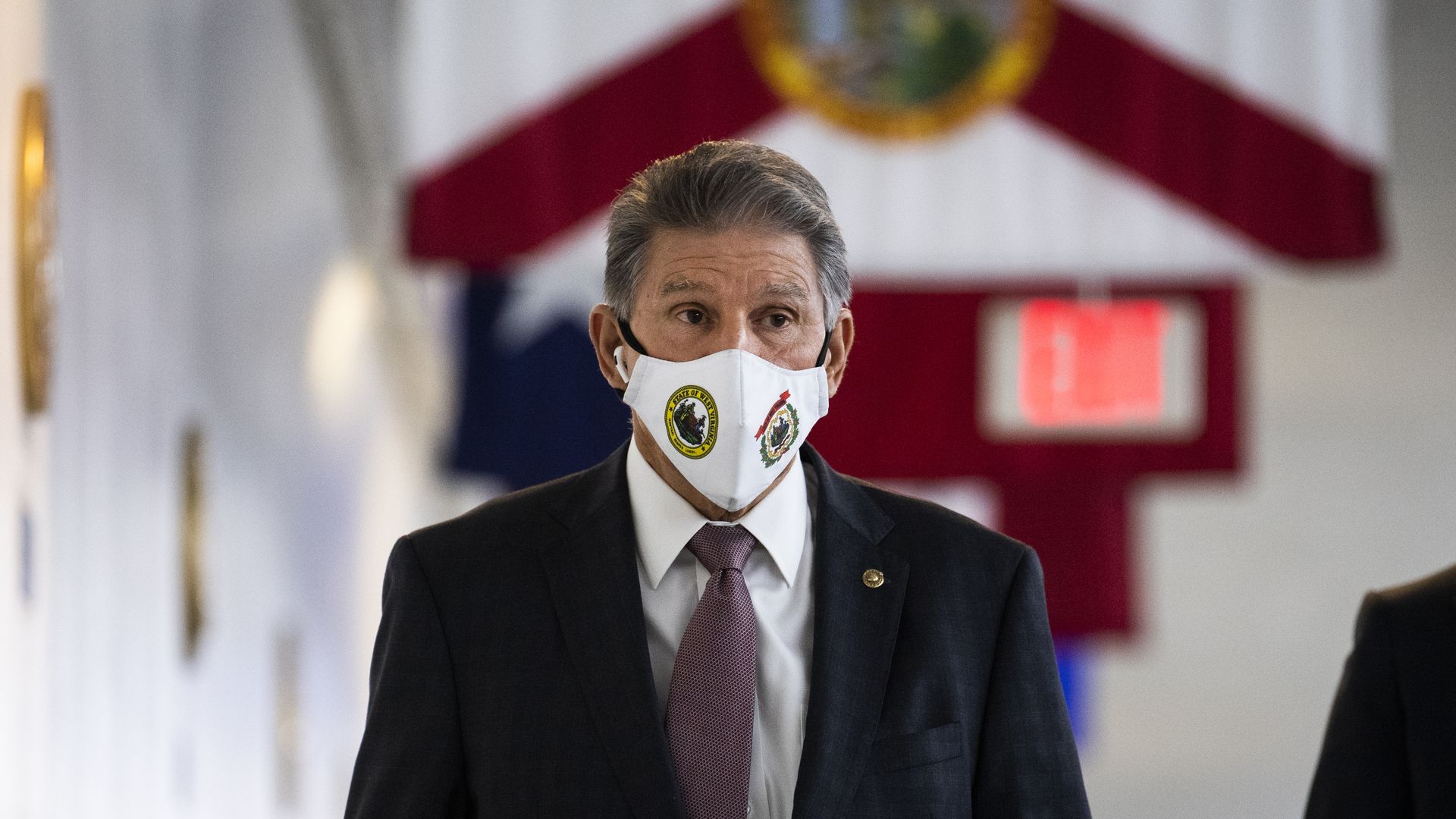 Sen. Joe Manchin is seen walking past Florida's state flag as he enters the U.S. Capitol.