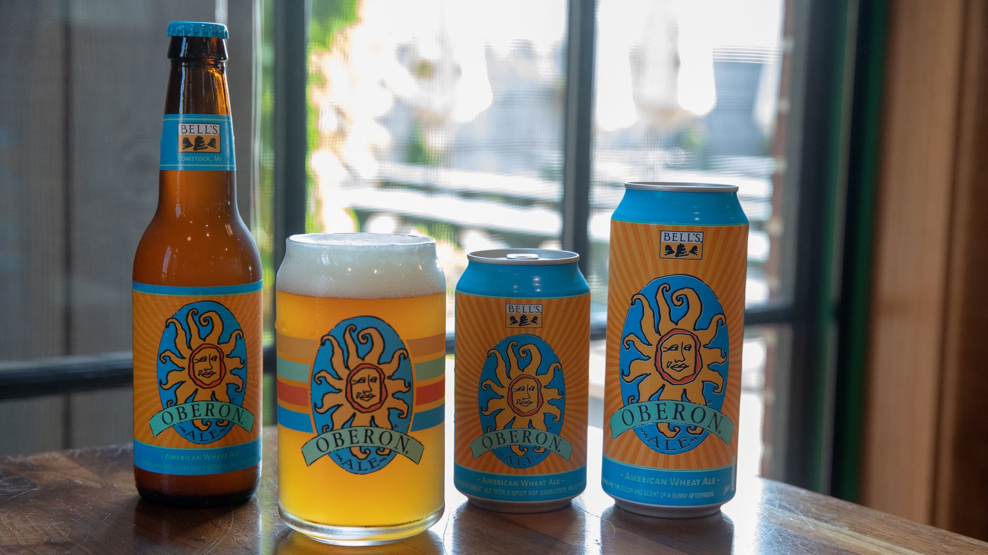 A glass and can of Bell's Oberon beer sits on the bar.