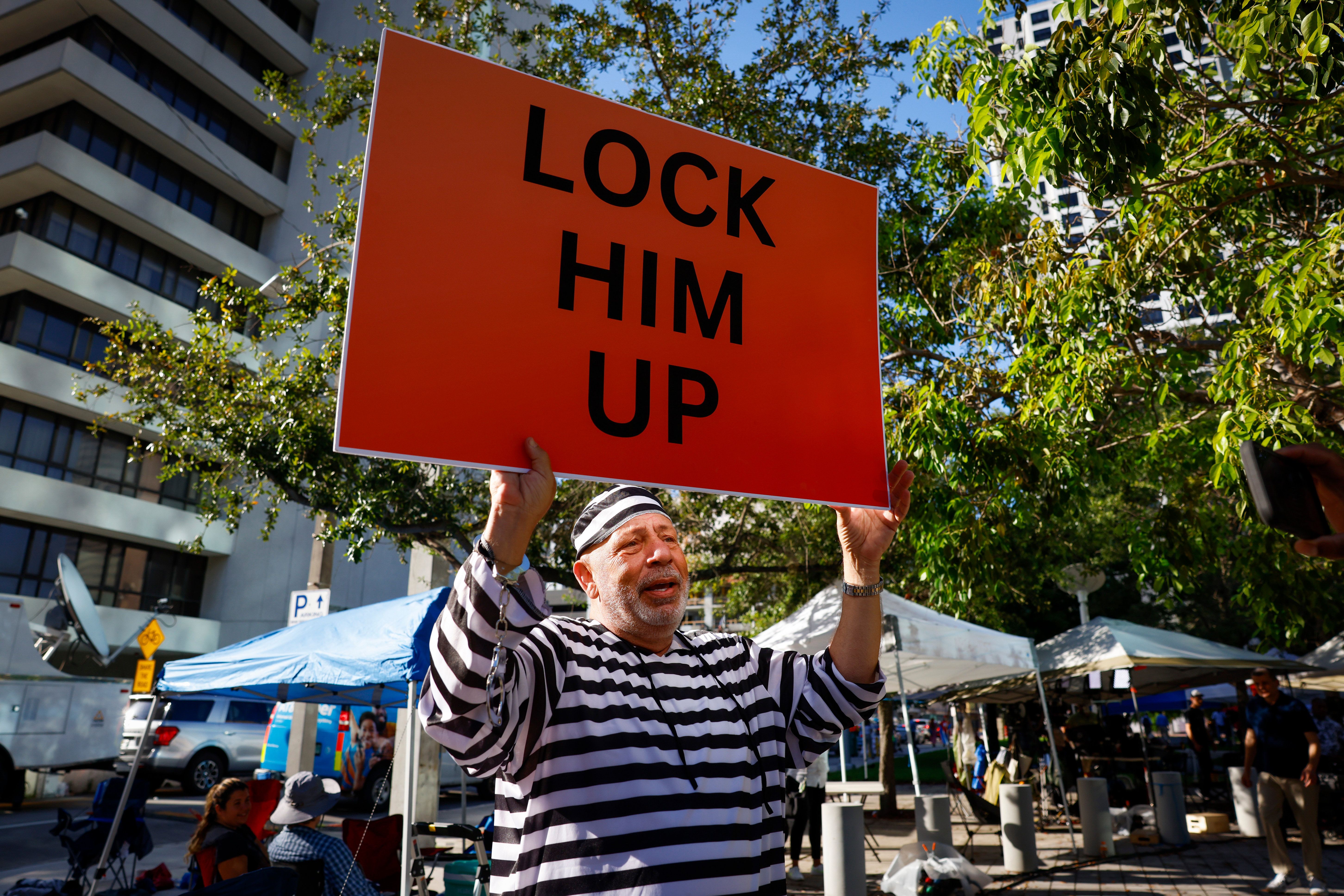 A protestor holds a "Lock Him Up" sign outside the Wilkie D. Ferguson Jr. United States Courthouse in Miami, Florida, US, on Tuesday, June 13, 2023.