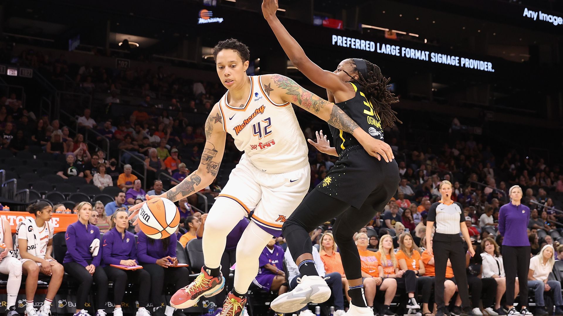 Brittney Griner dribbles a basketball past Chiney Ogwumike.