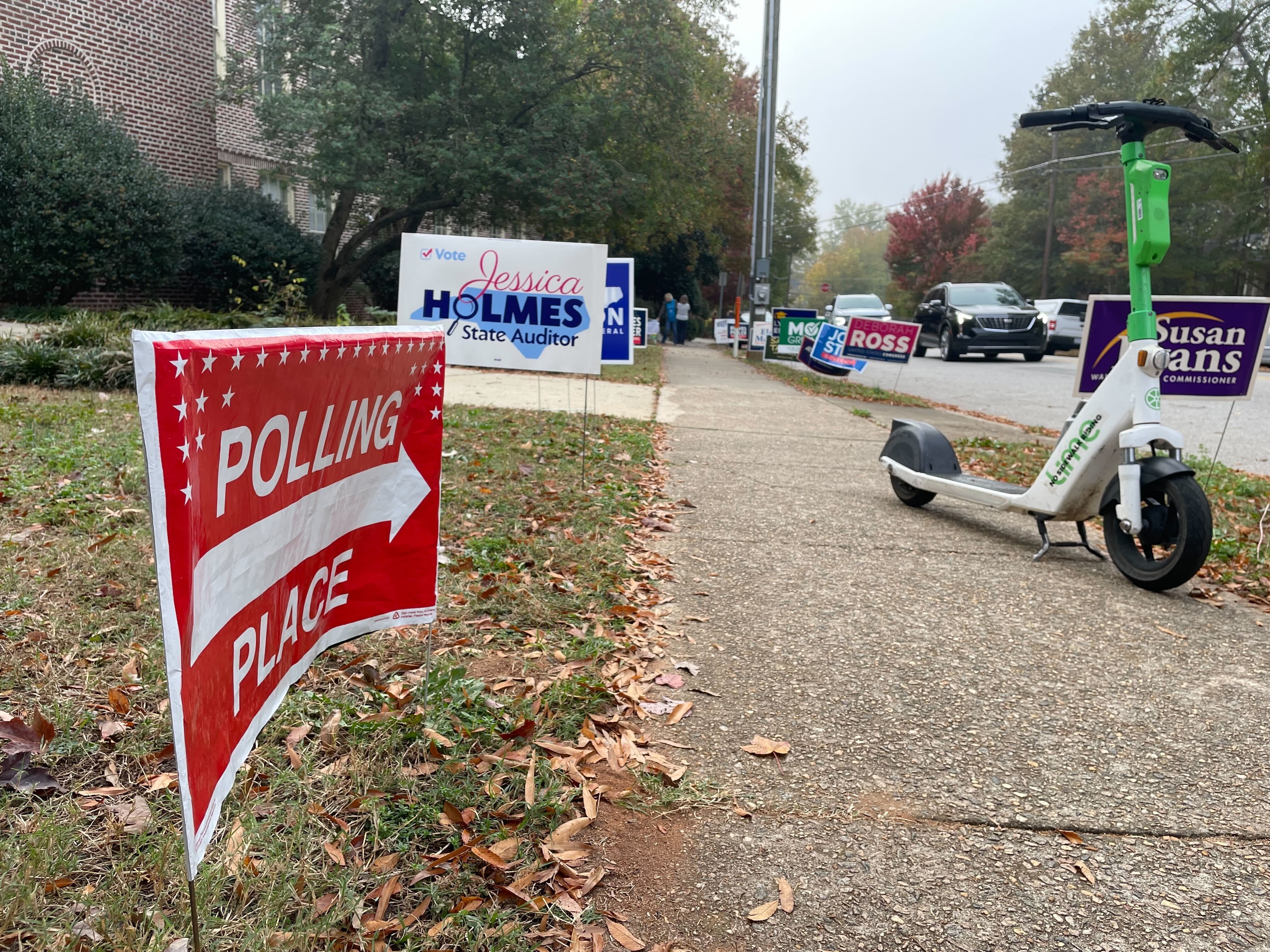 polling place signs and a scooter on a sidewalk 