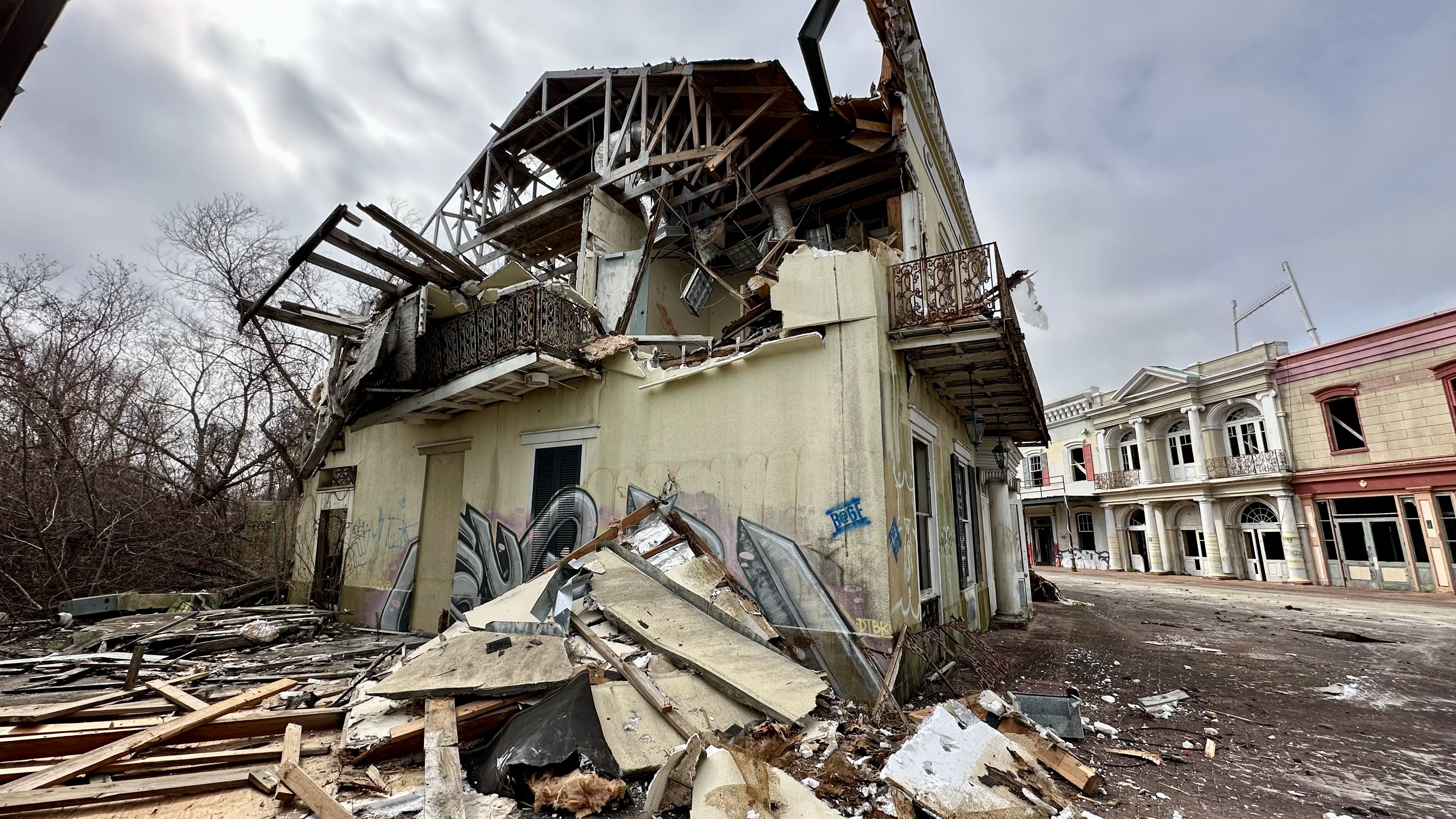 Photo shows a building being demolished.