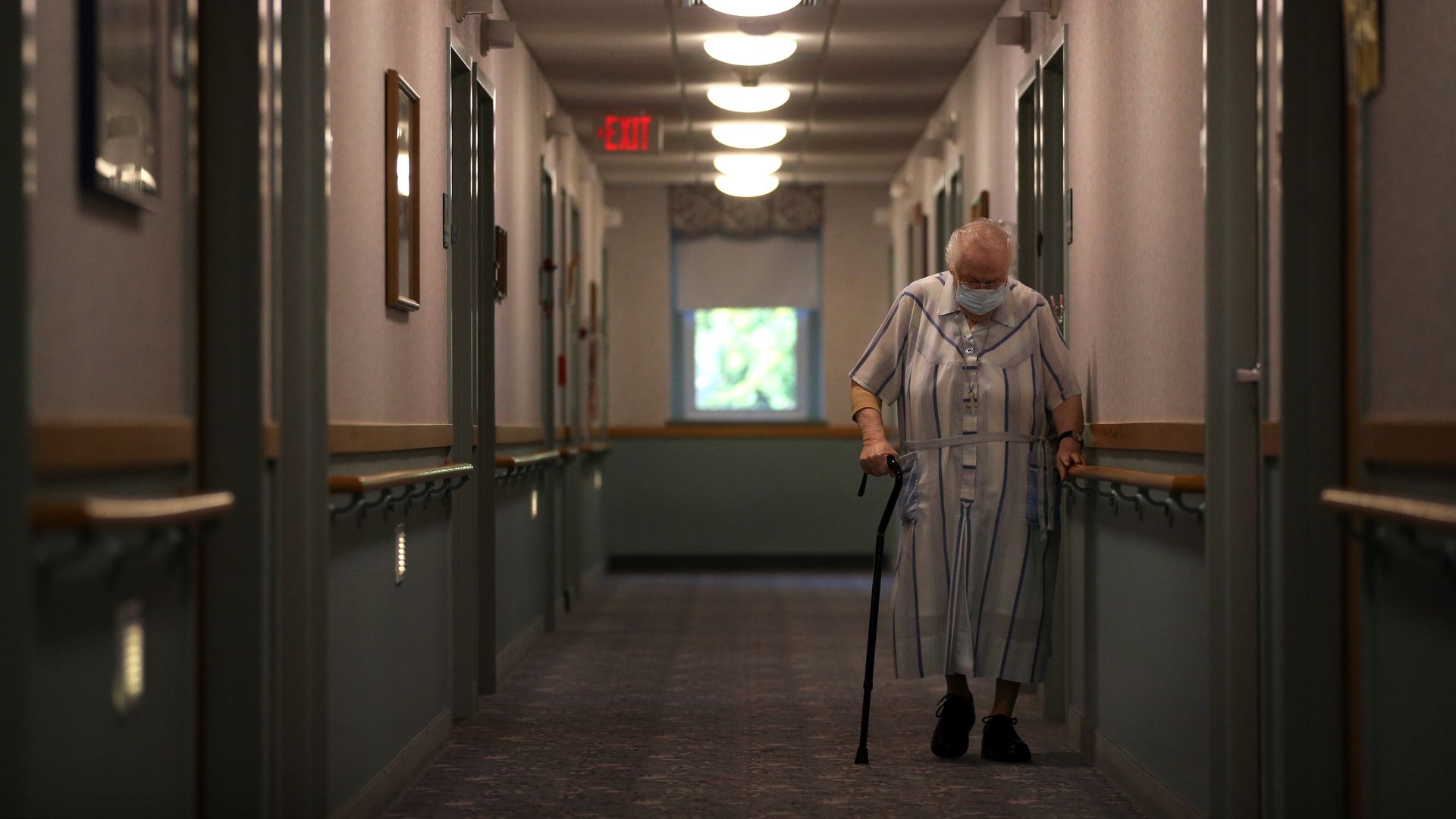 Picture of a hallway in a nursing home with an elder person walking
