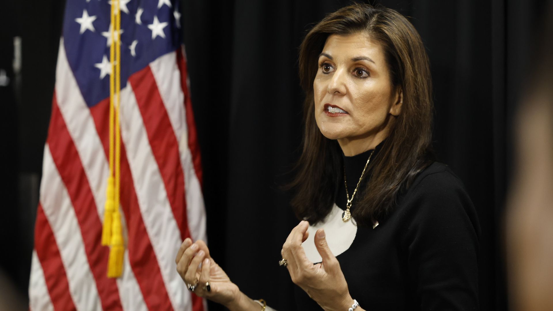 Nikki Haley address reporters next to an American flag.