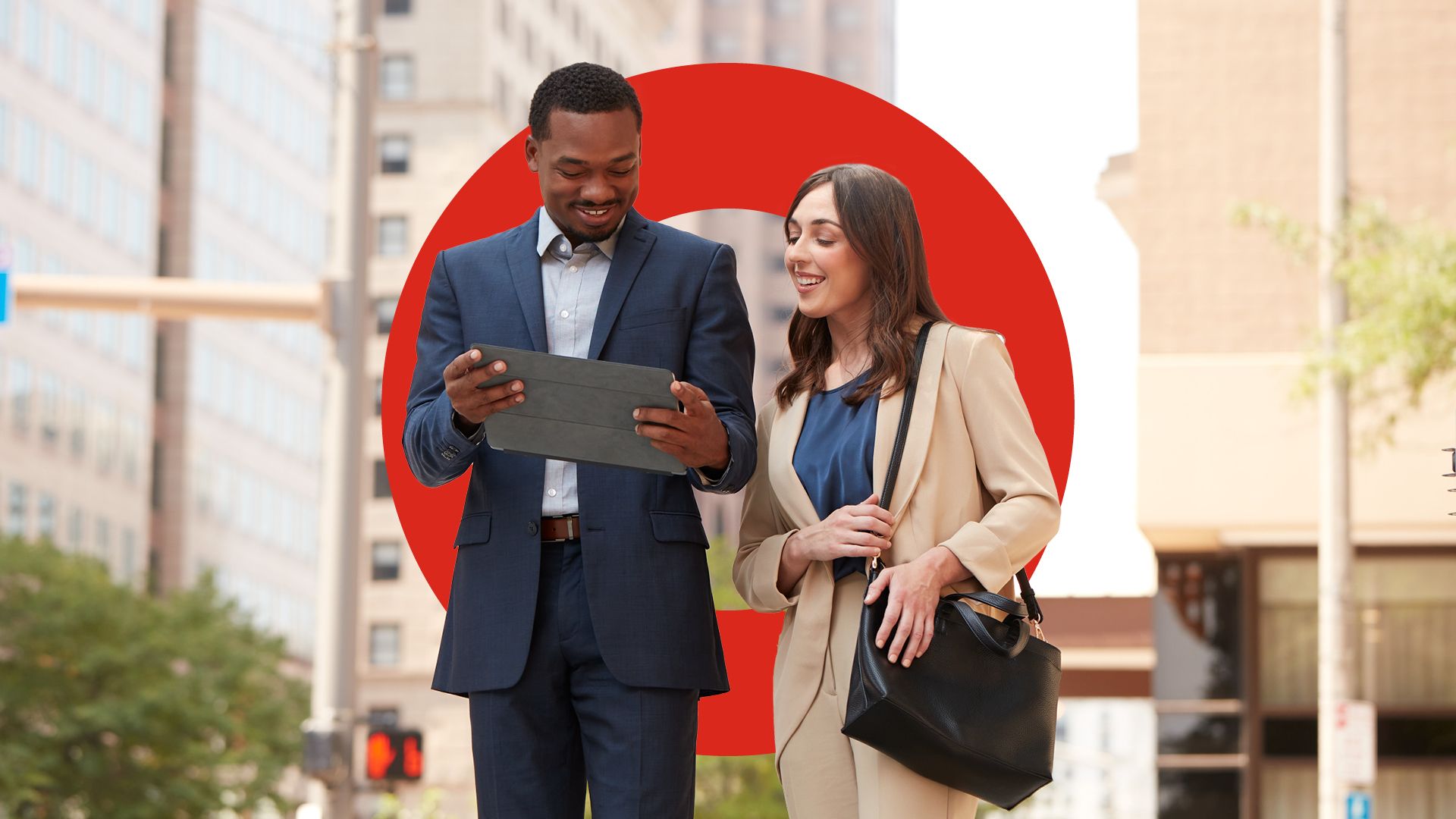 Two people in business attire looking at a device.