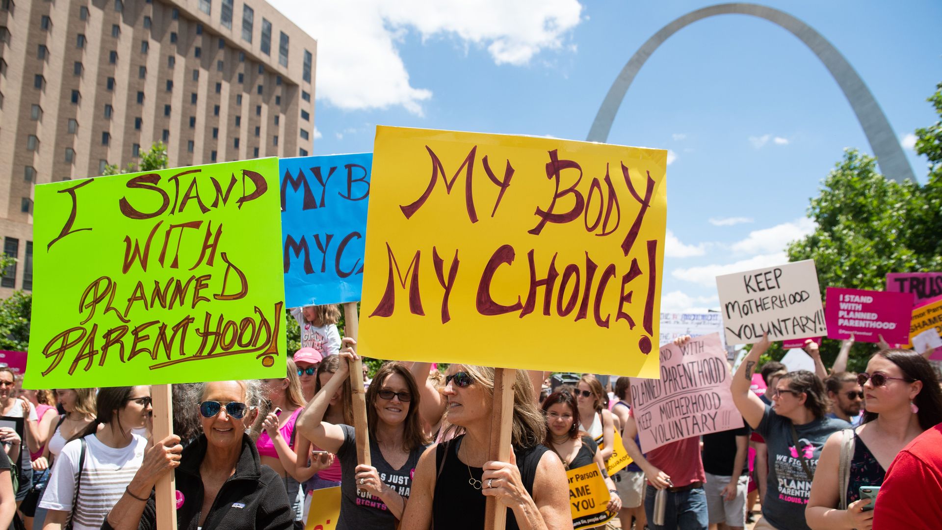Protestors gathered in support of Planned Parenthood with the St. Louis Gateway Arch in the background.