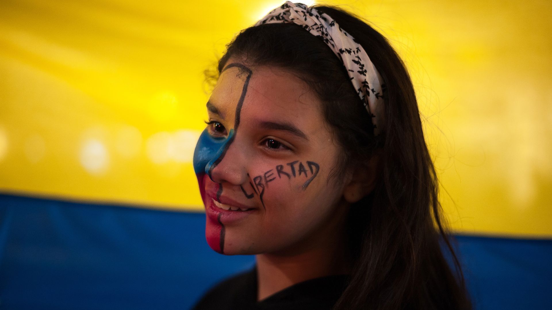 A Venezuelan protester with "Freedom" painted on her face.